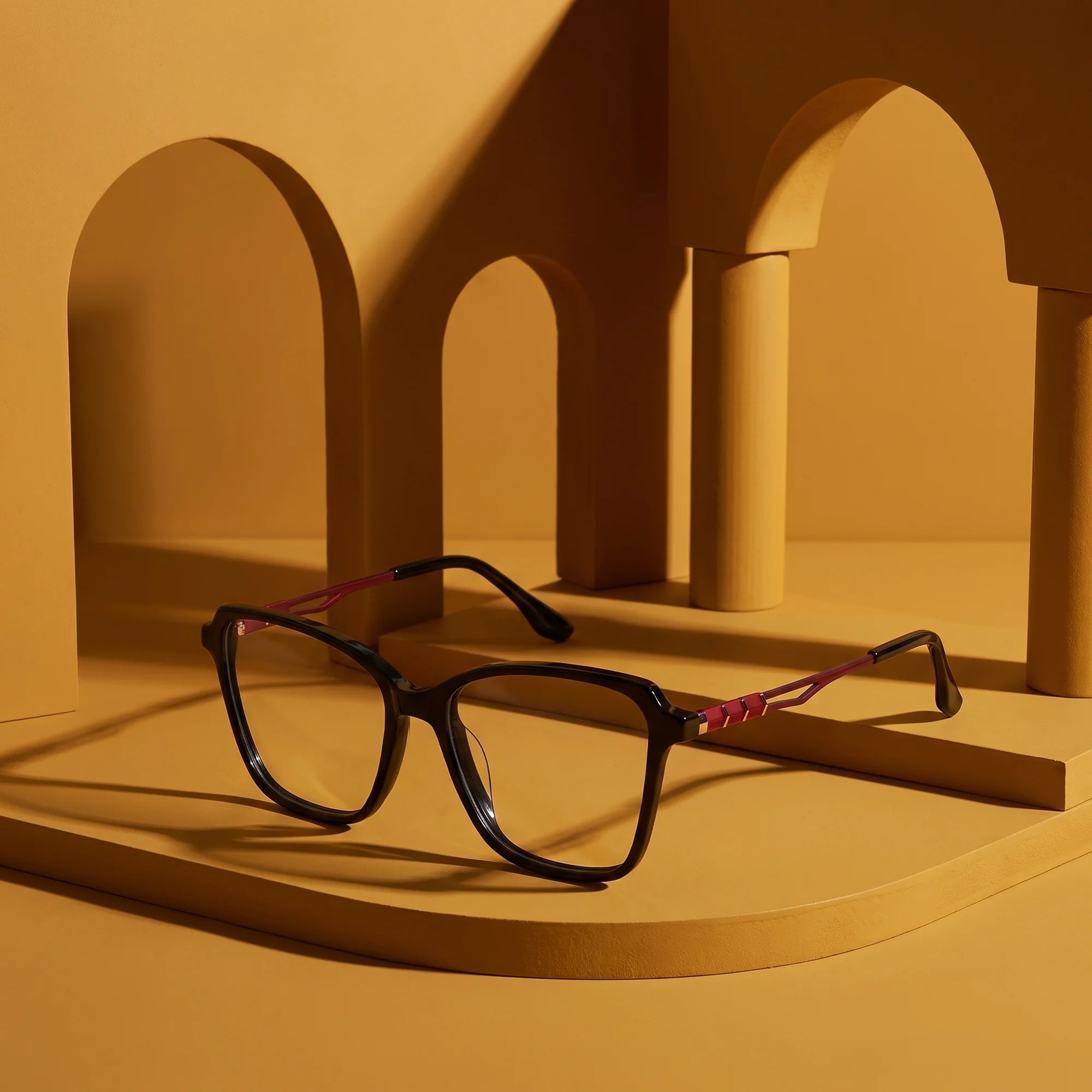 Fiore 1006 eyeglasses in black – still life among monochrome mustard ochre arches