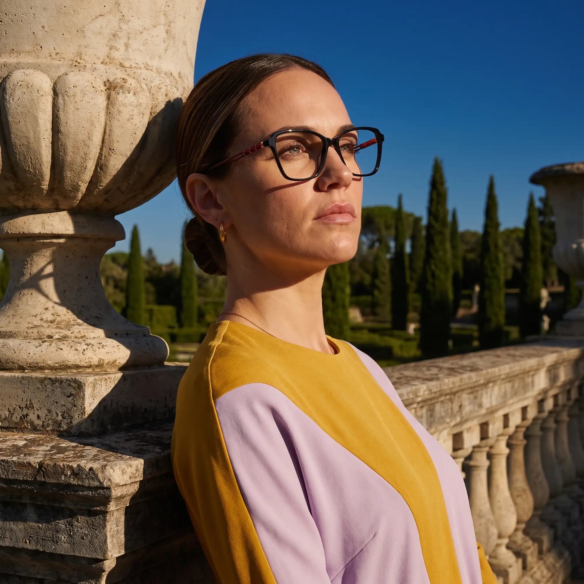 Fiore 1006 eyeglasses in black, worn by a model – campaign portrait, dusk light over a cypress garden