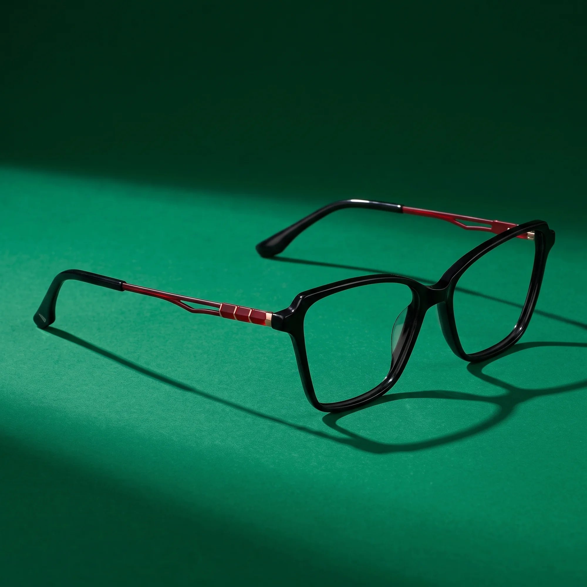 Fiore 1006 eyeglasses in black – editorial still life on a saturated emerald set