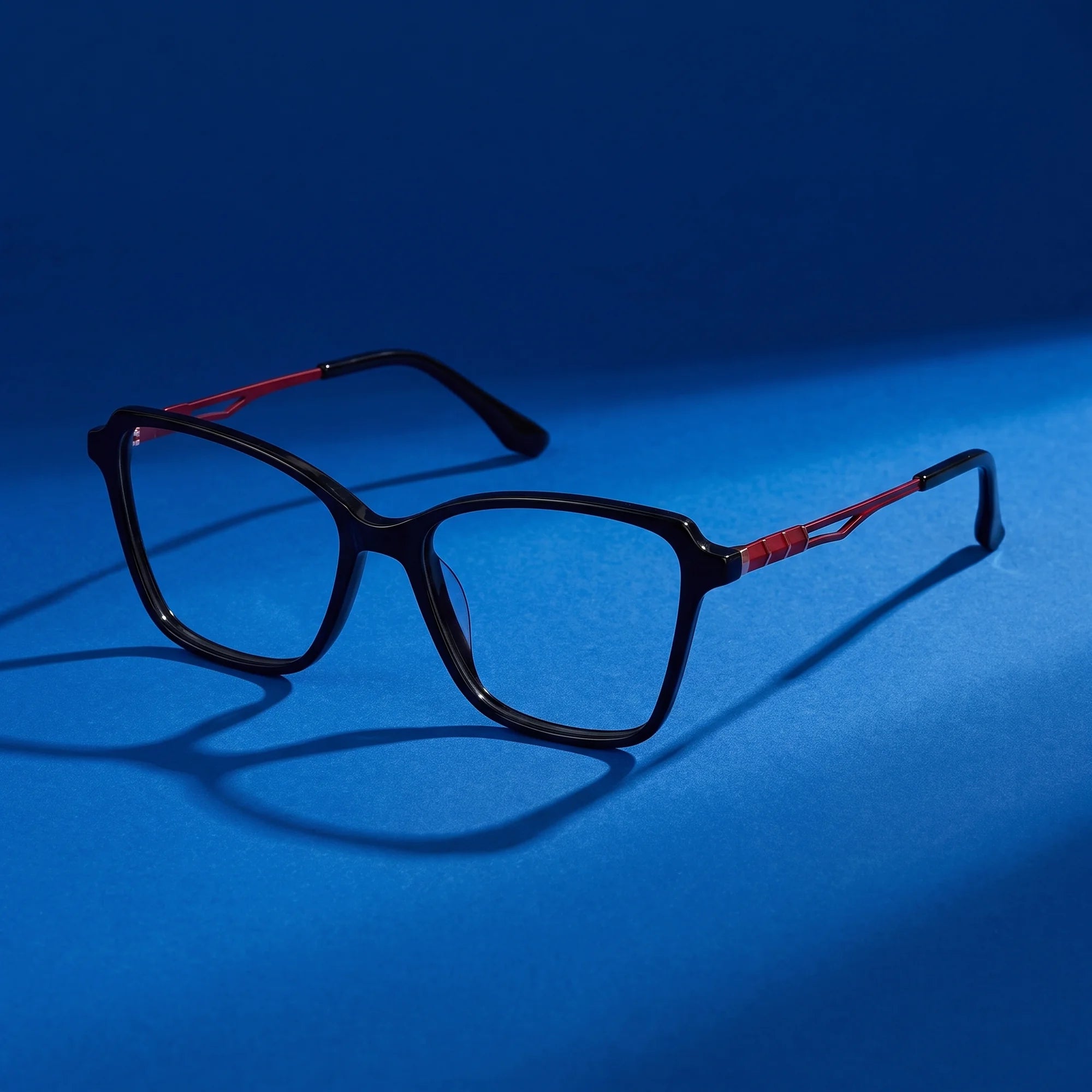 Fiore 1006 eyeglasses in black – still life on a seamless cobalt studio backdrop