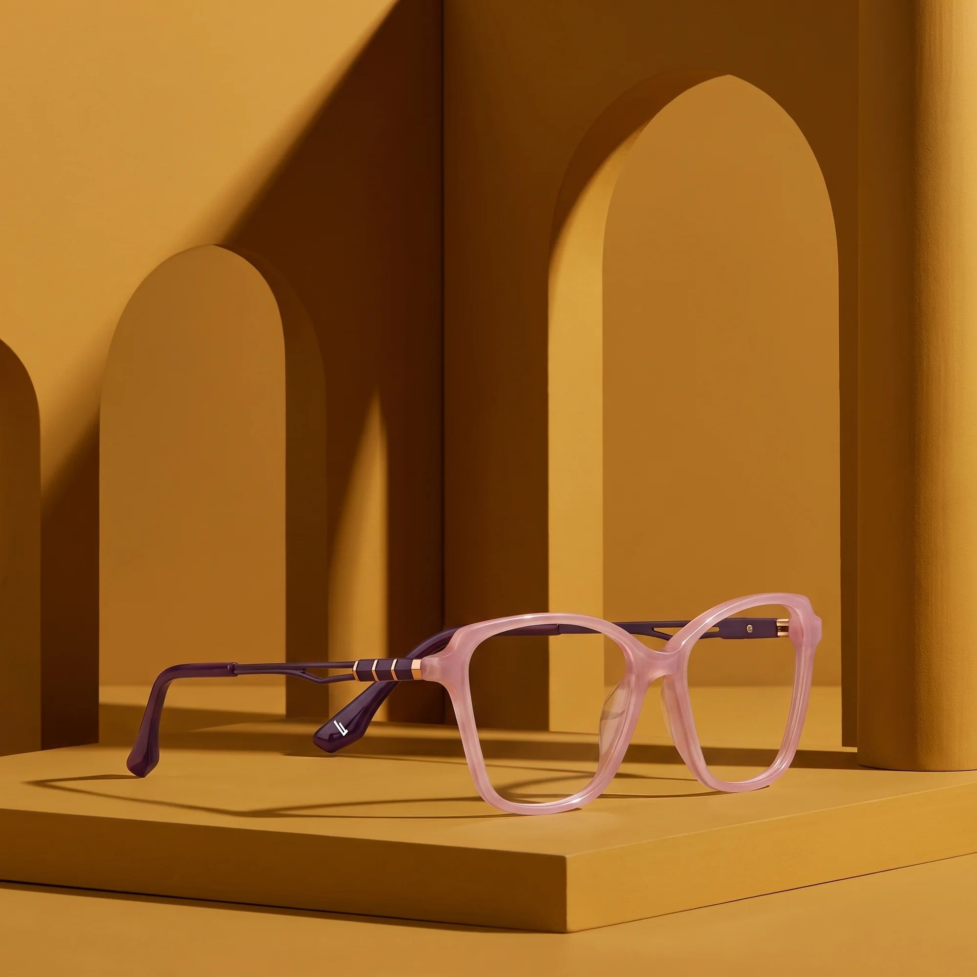 Fiore 1006 eyeglasses in pink – still life among monochrome mustard ochre arches