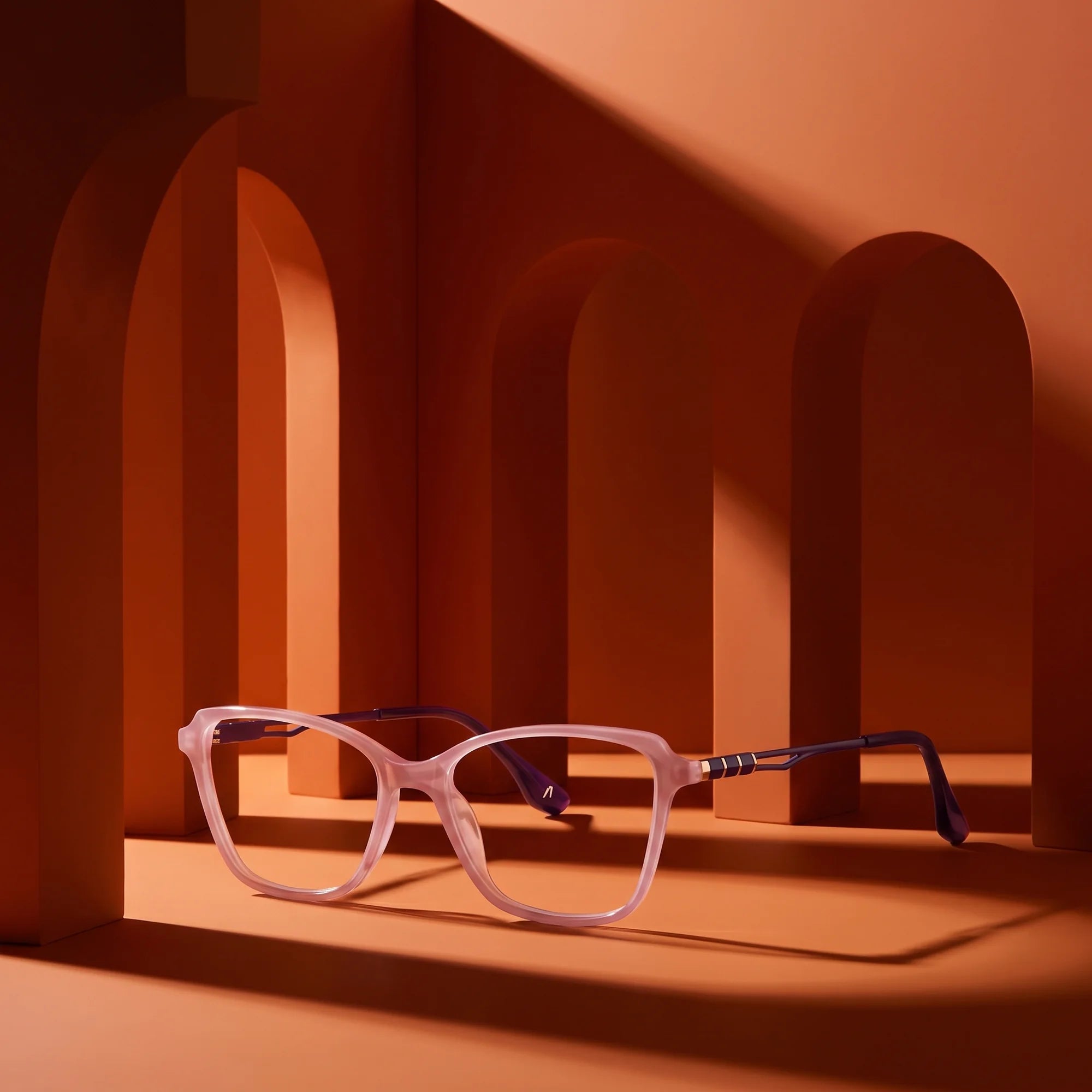 Fiore 1006 eyeglasses in pink – staged on a sculptural burnt orange architecture set