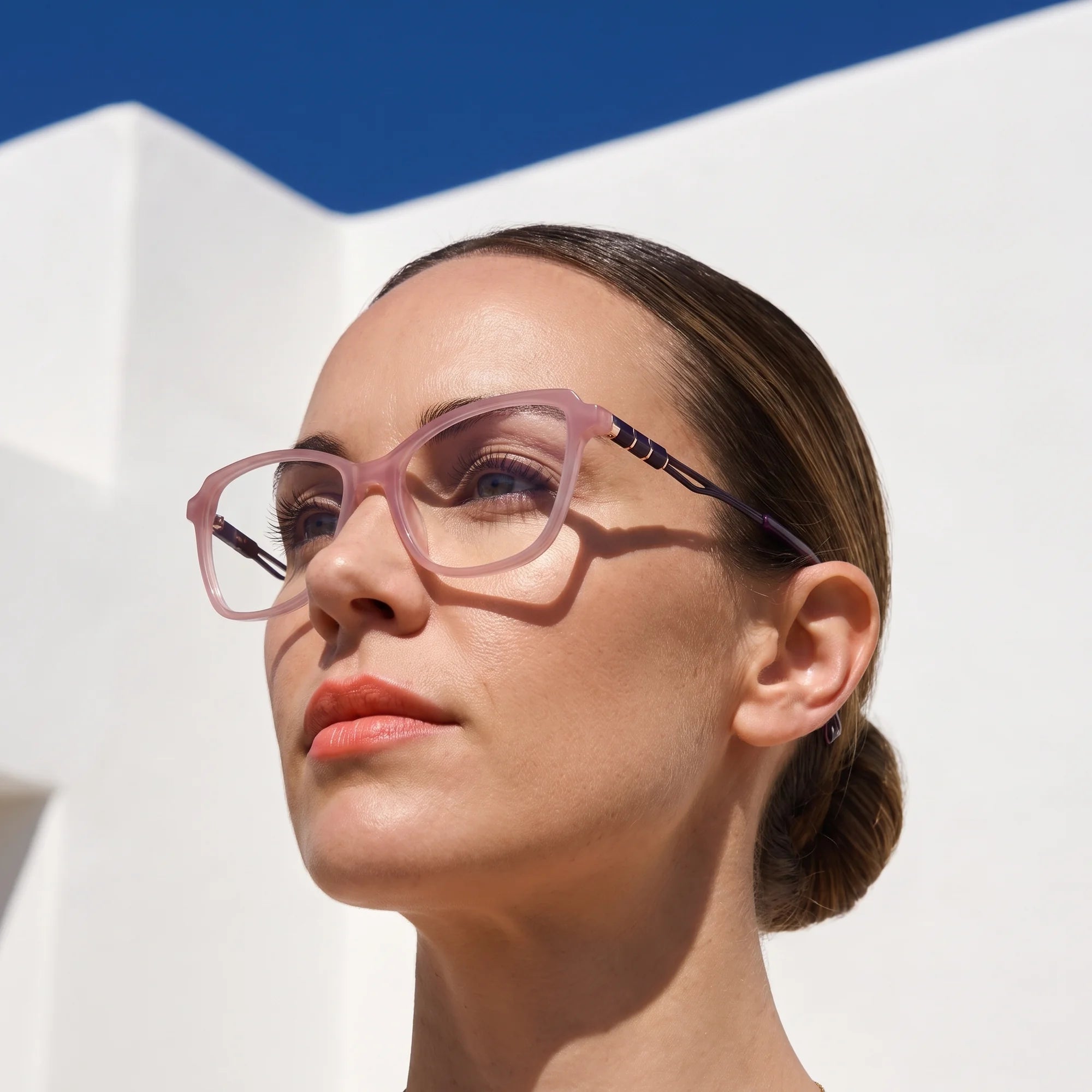 Fiore 1006 eyeglasses in pink, worn by a model – campaign portrait, sunlit Balearic whitewash and deep blue sky