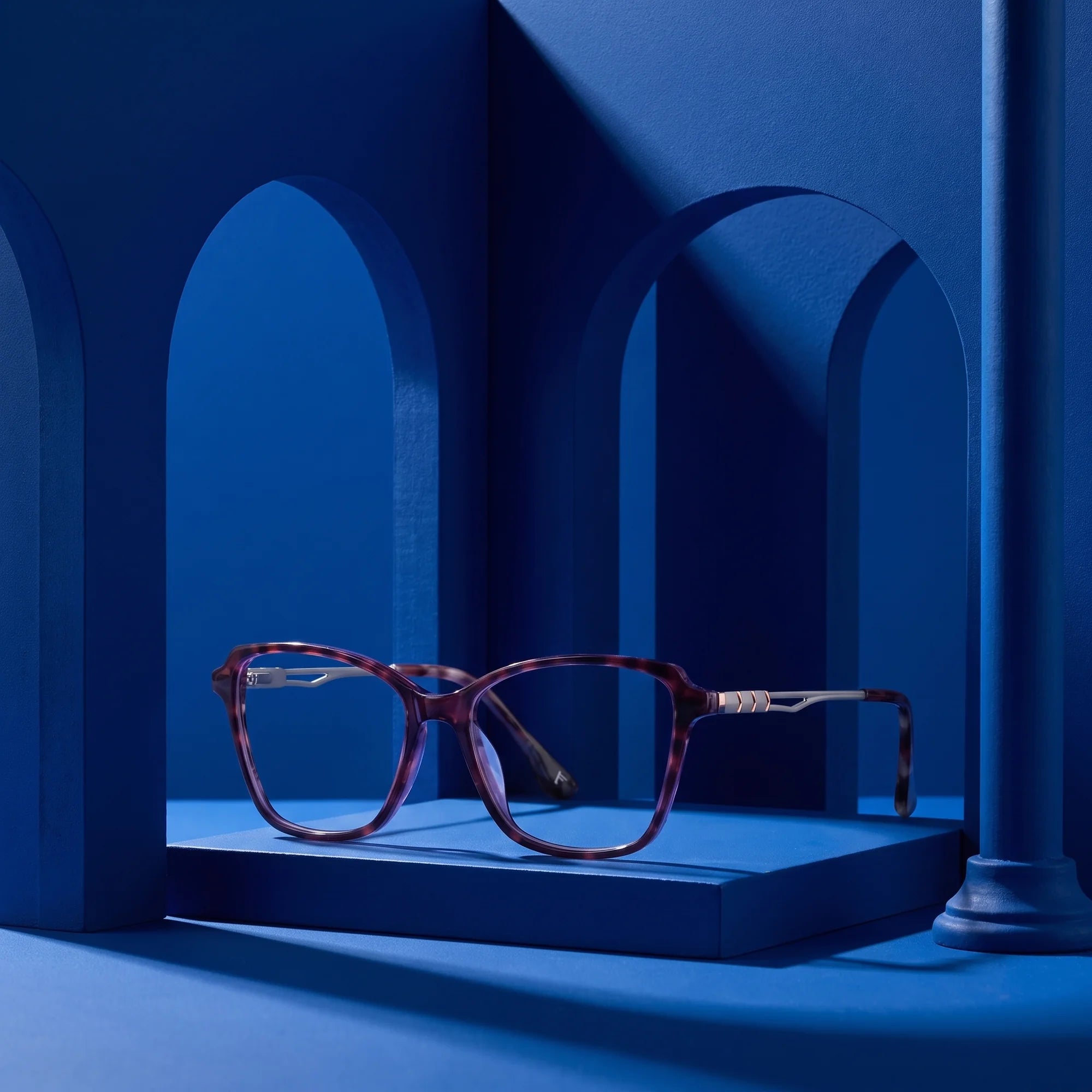 Fiore 1006 eyeglasses in purple – staged on a sculptural cobalt architecture set
