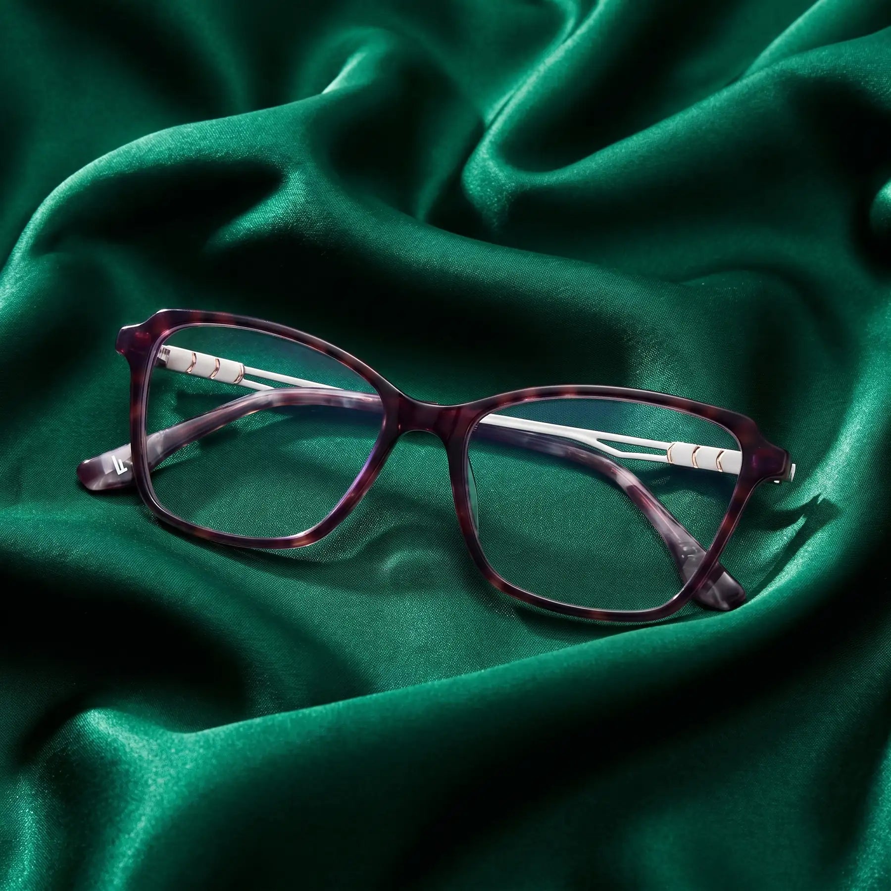 Fiore 1006 eyeglasses in purple – nested in flowing emerald silk