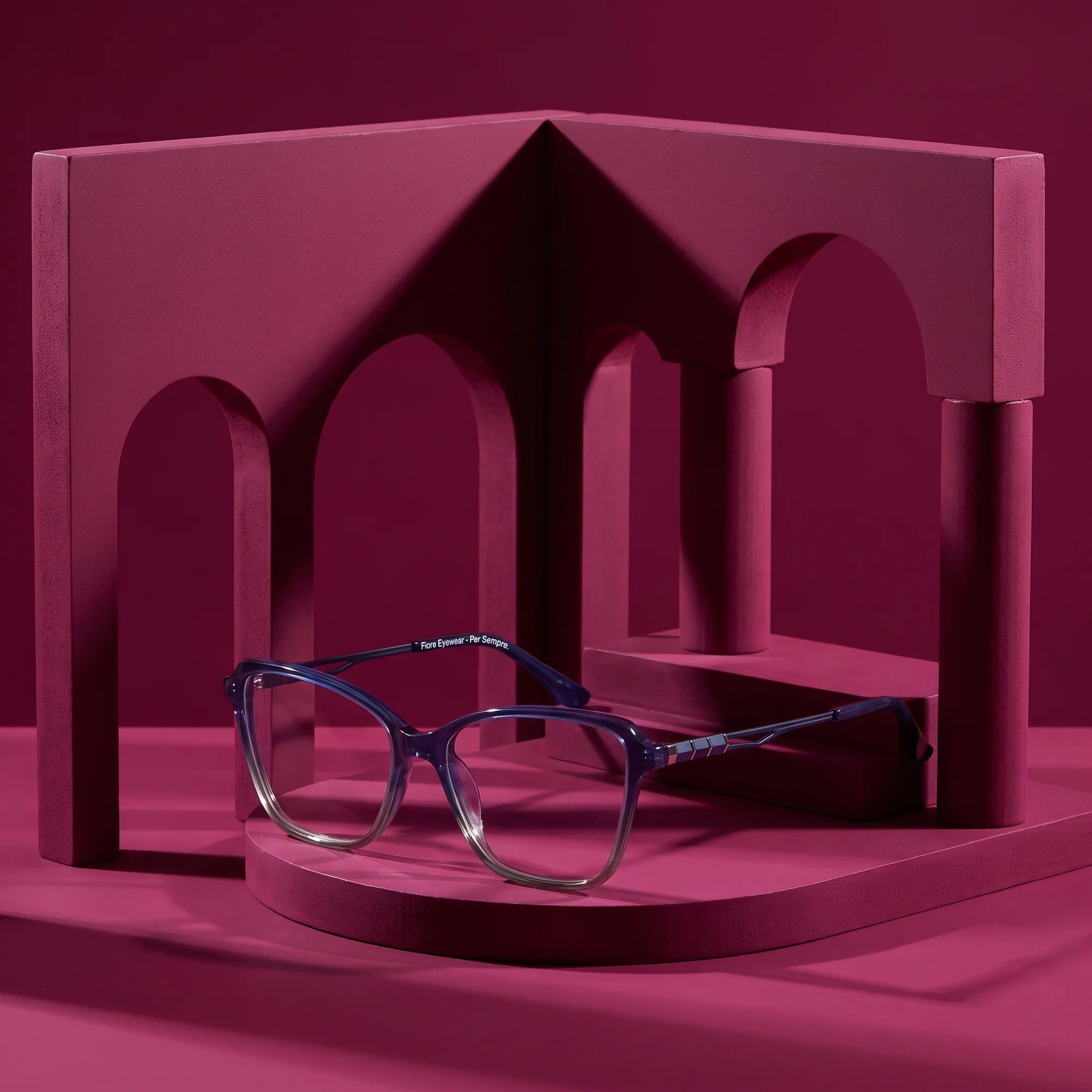 Fiore 1006 eyeglasses in blue – still life among monochrome magenta arches