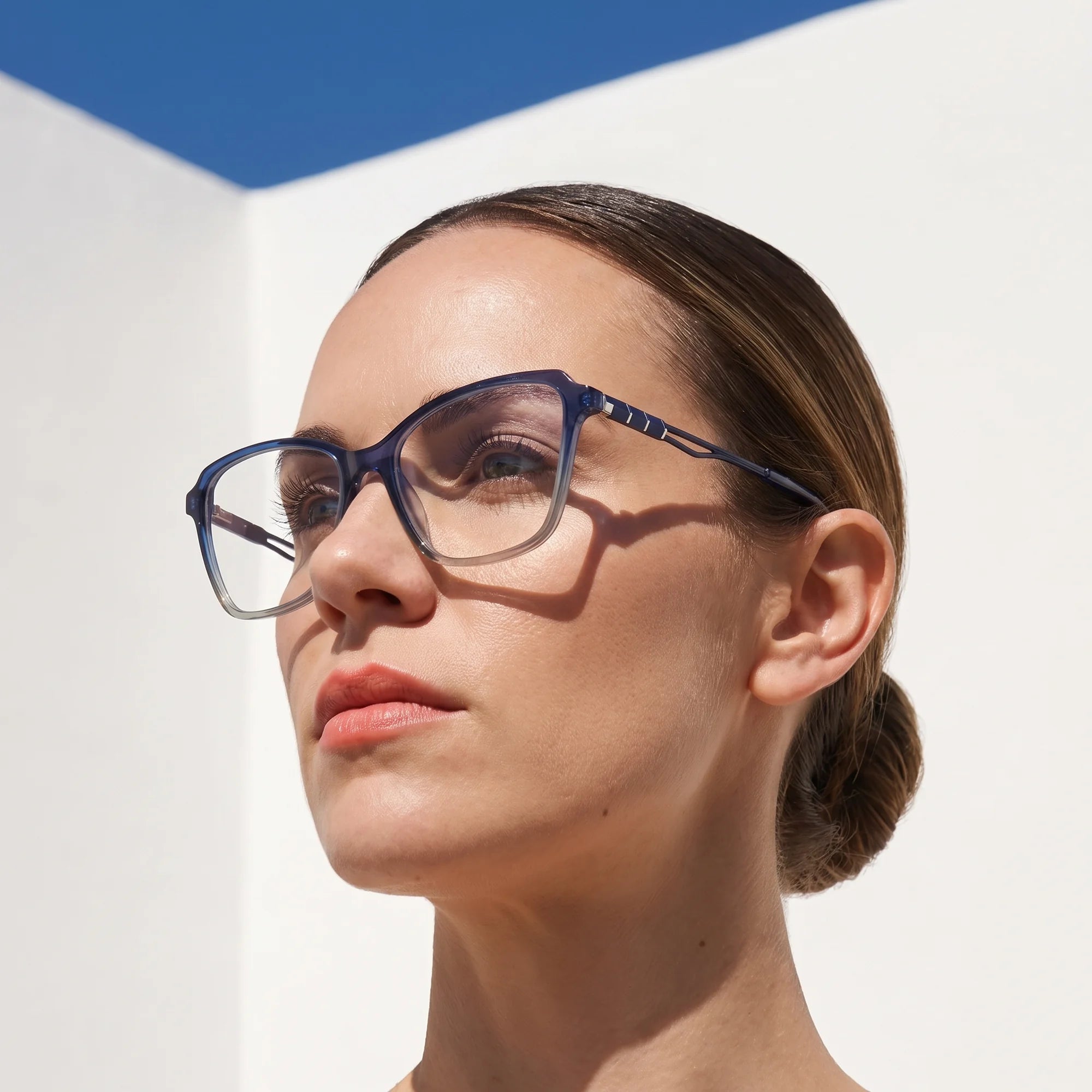 Fiore 1006 eyeglasses in blue, worn by a model – campaign portrait, sunlit Balearic whitewash and deep blue sky