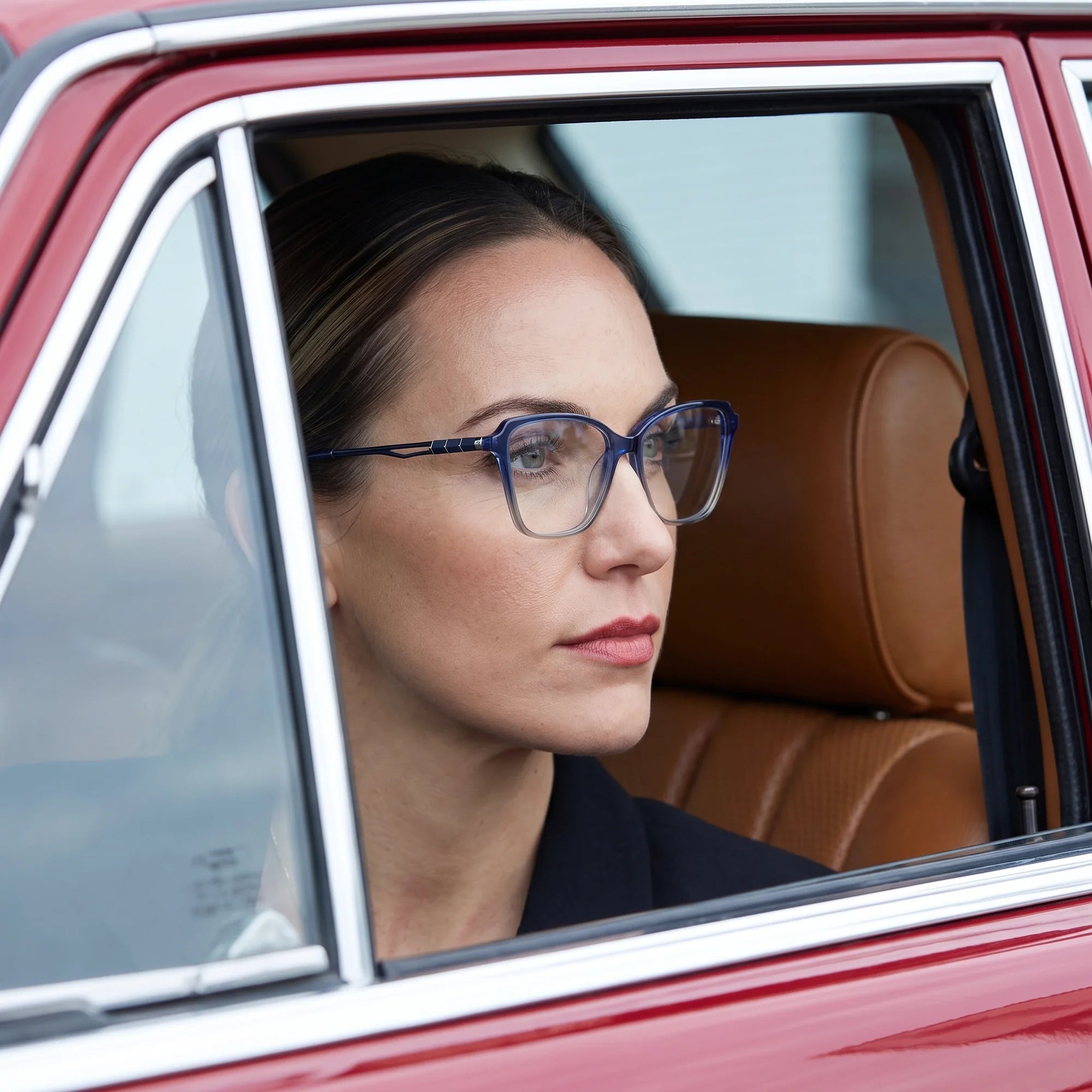 Fiore 1006 eyeglasses in blue, worn by a model – campaign portrait, gaze through a classic red car window