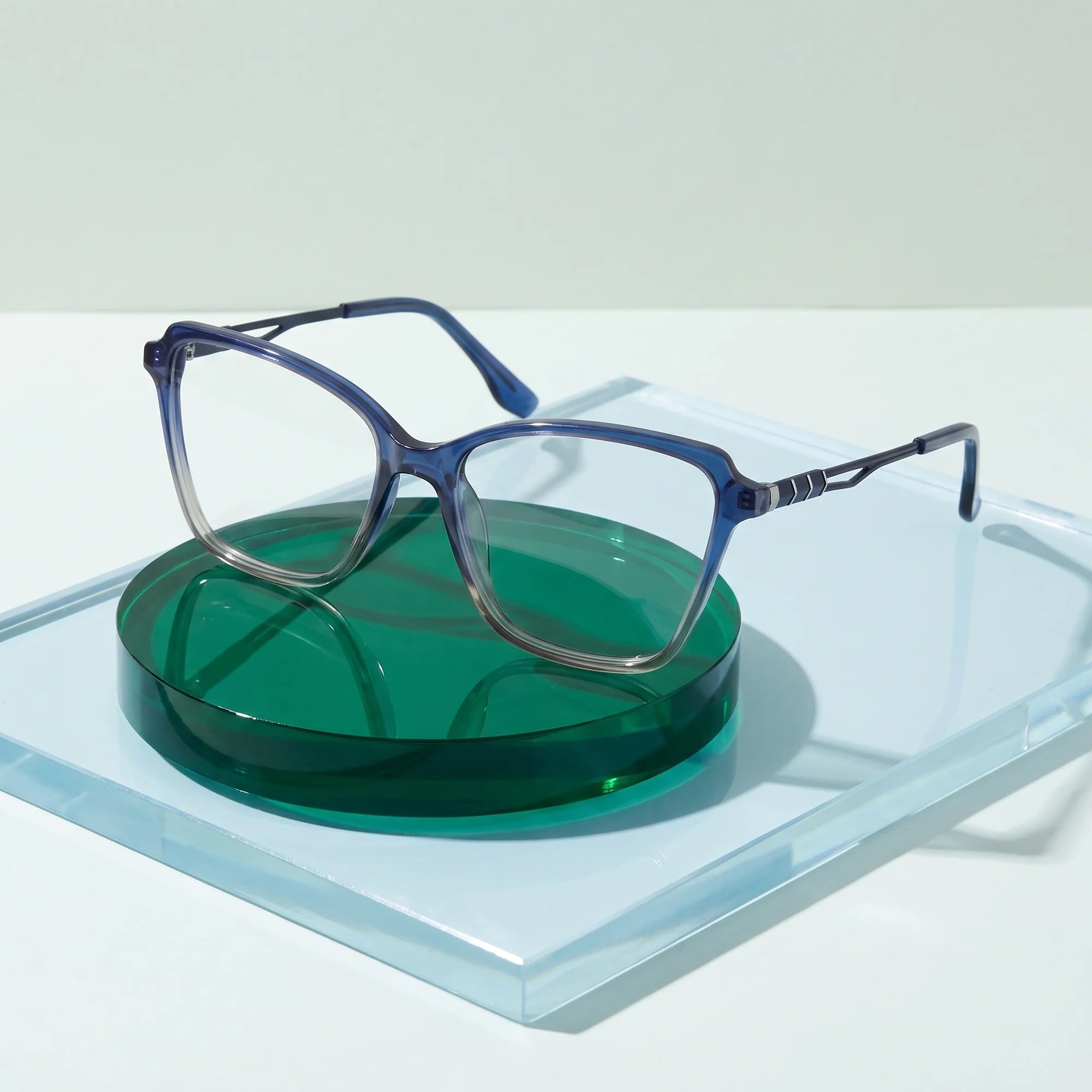 Fiore 1006 eyeglasses in blue – on a cobalt acrylic disc in soft daylight