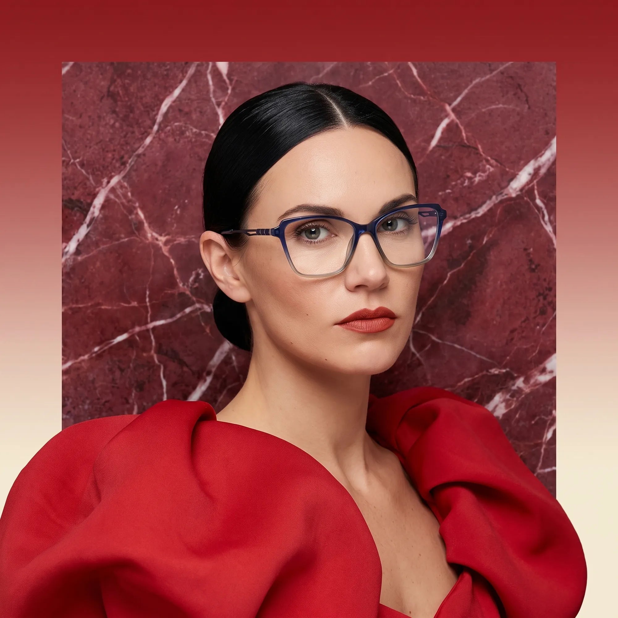 Fiore 1006 eyeglasses in blue, worn by a model – campaign portrait, red marble backdrop and draped scarlet dress