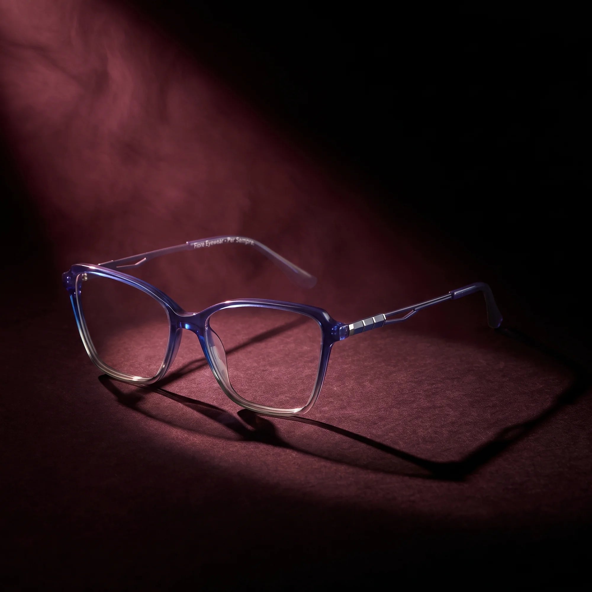 Fiore 1006 eyeglasses in blue – under a theatrical beam of light