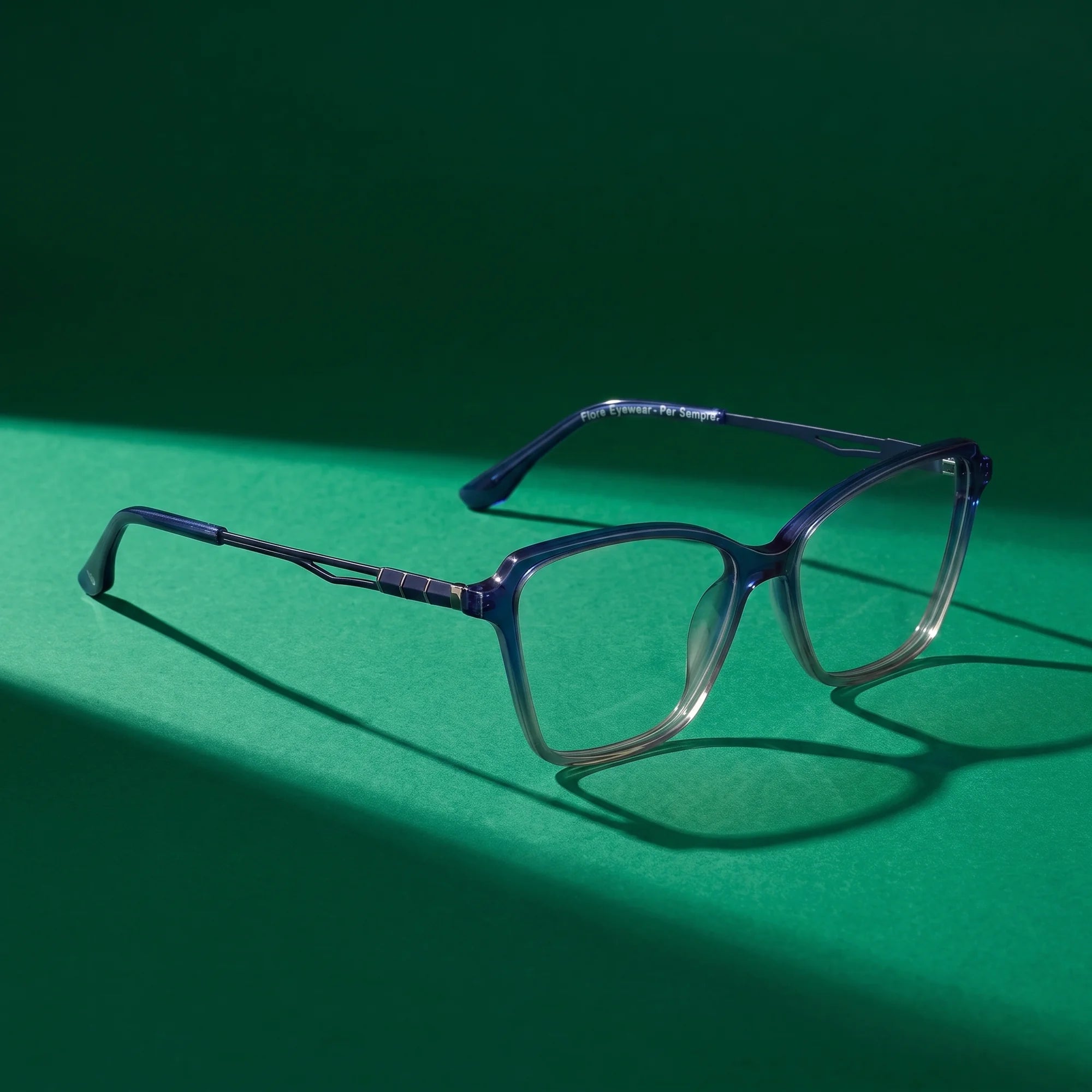 Fiore 1006 eyeglasses in blue – still life on a seamless emerald studio backdrop