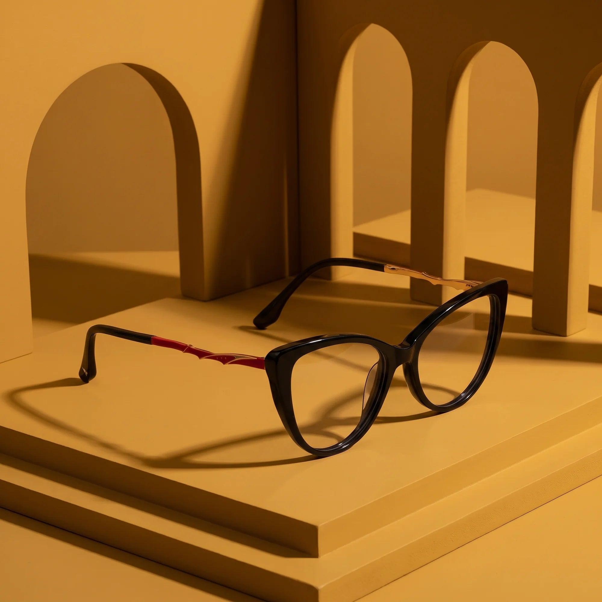 Fiore 1010 eyeglasses in black – still life among monochrome mustard ochre arches