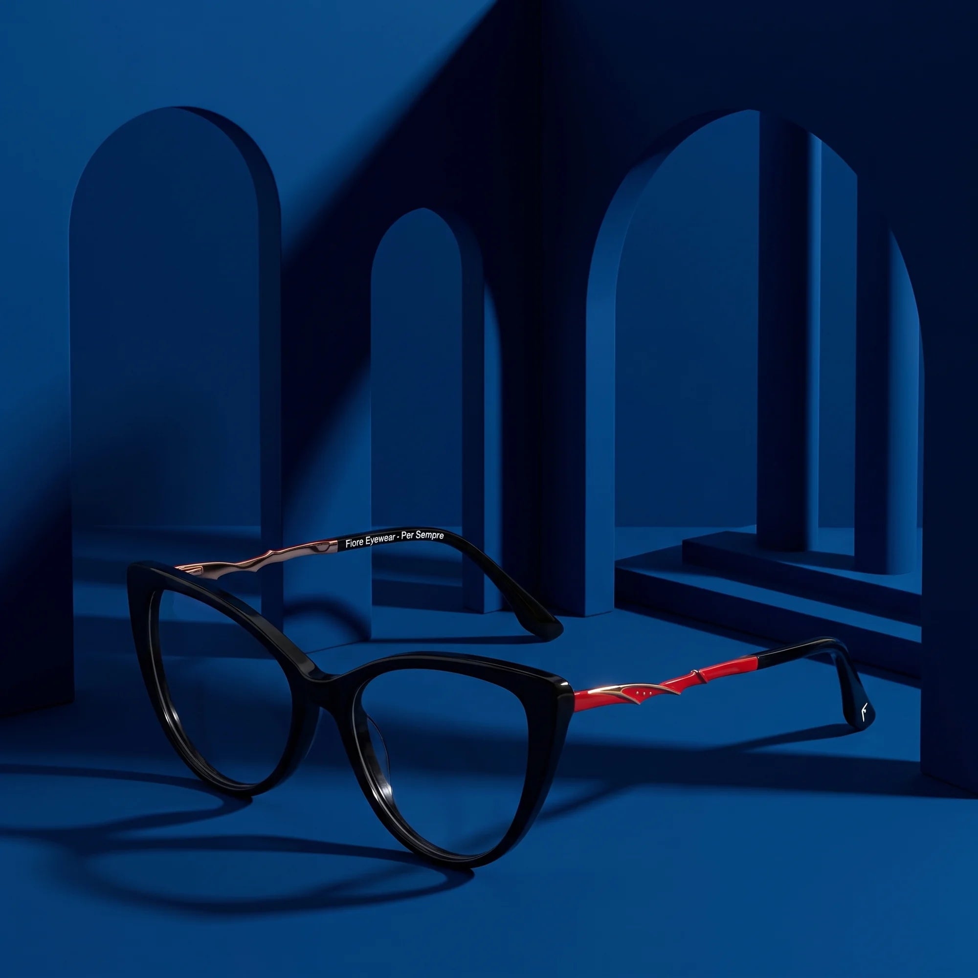Fiore 1010 eyeglasses in black – displayed on a midnight blue podium among arches