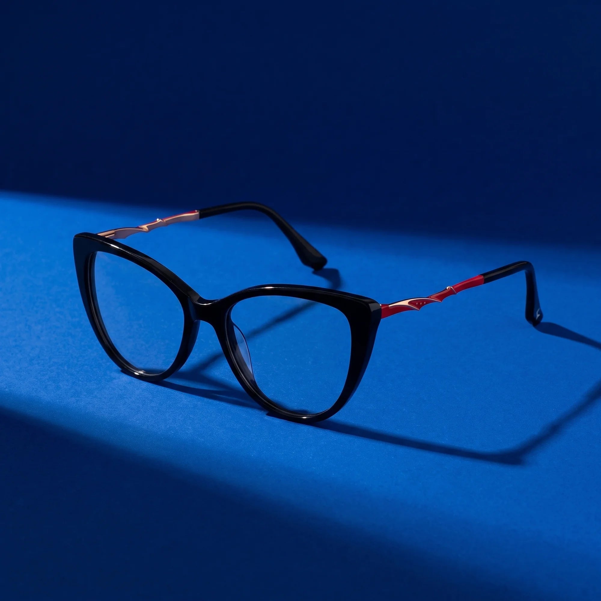Fiore 1010 eyeglasses in black – still life on a seamless cobalt studio backdrop