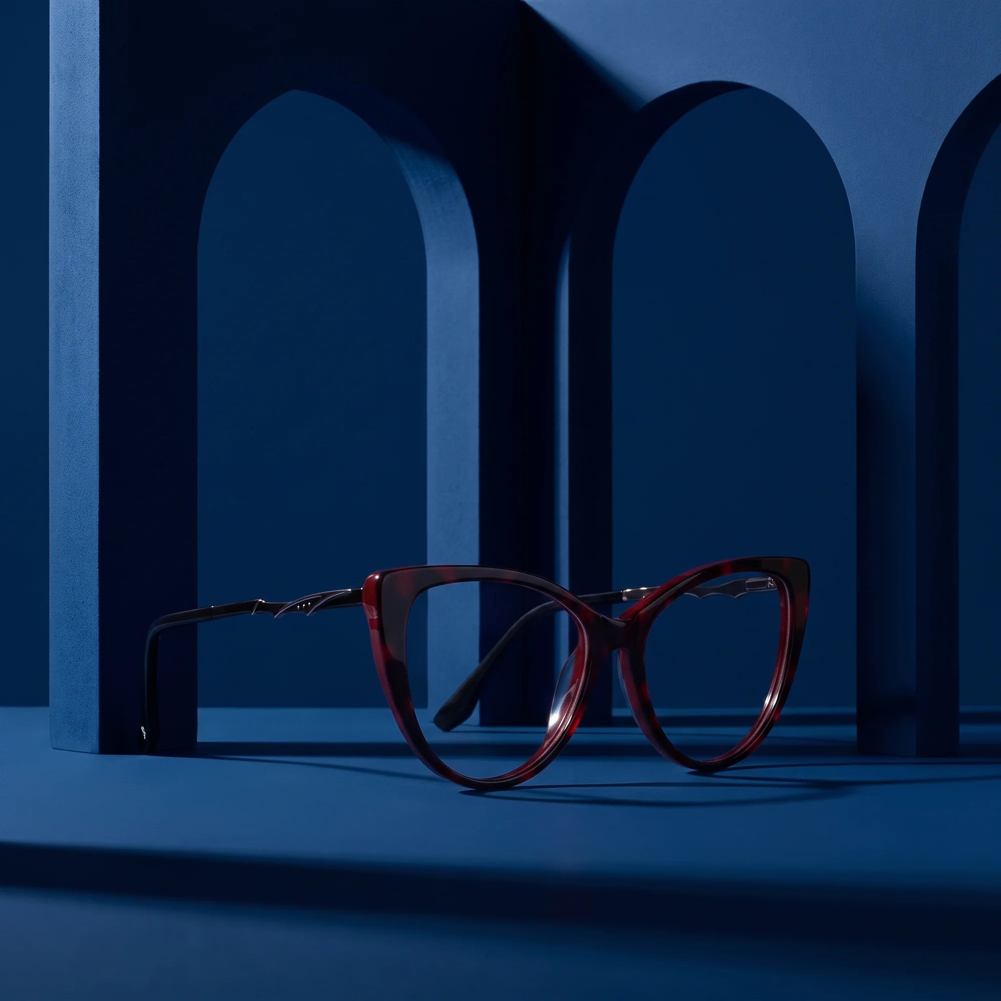 Fiore 1010 eyeglasses in red – staged on a sculptural midnight blue architecture set