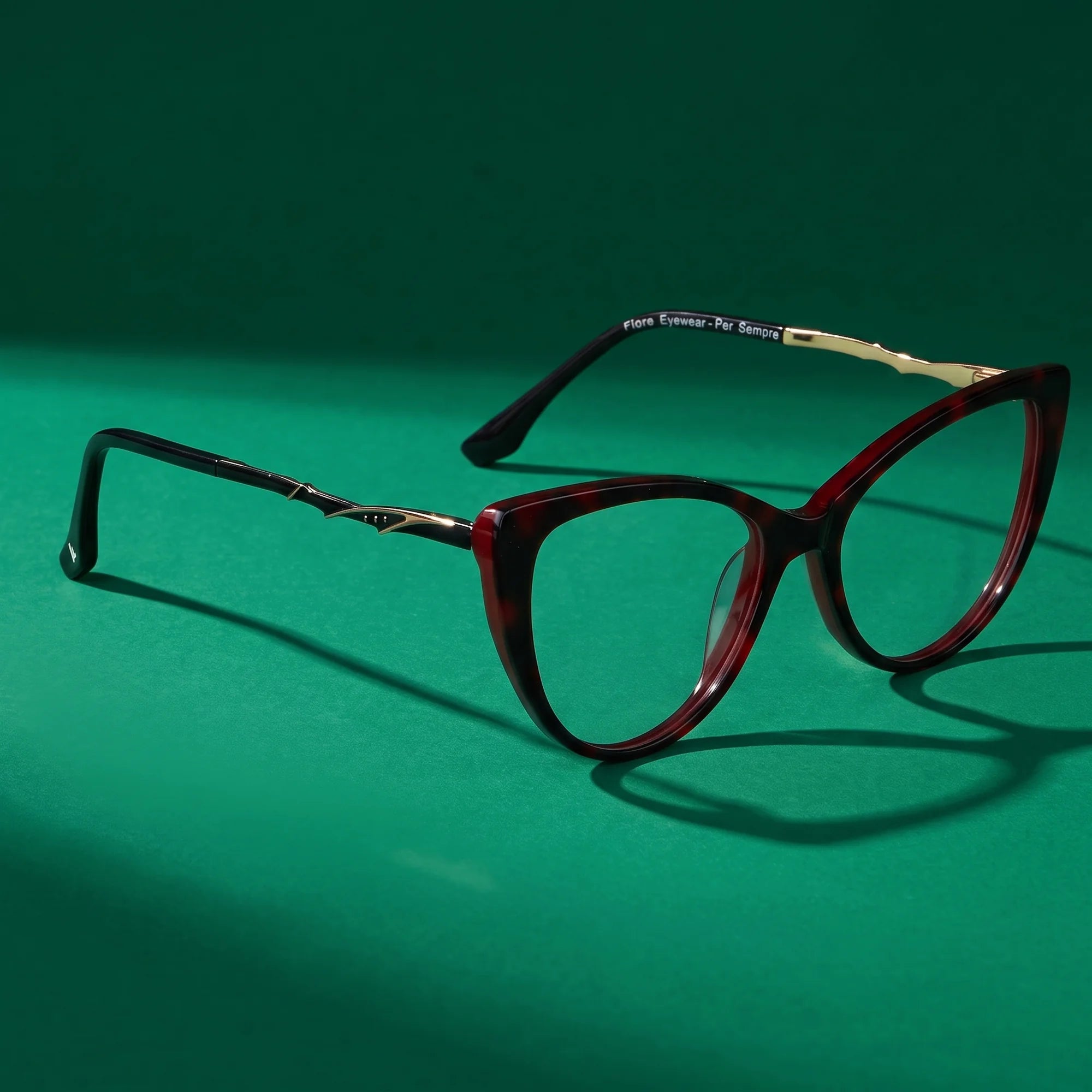 Fiore 1010 eyeglasses in red – editorial still life on a saturated emerald set