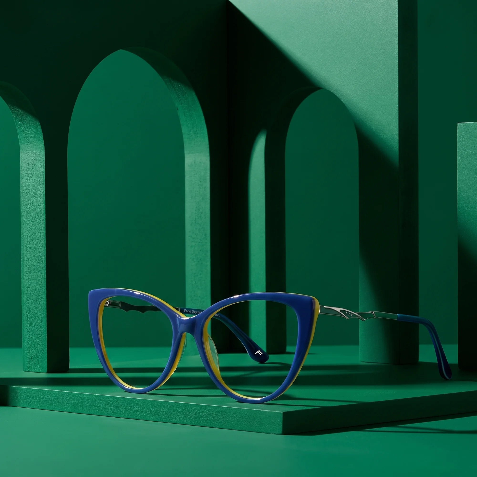 Fiore 1010 eyeglasses in blue green – staged on a sculptural emerald architecture set