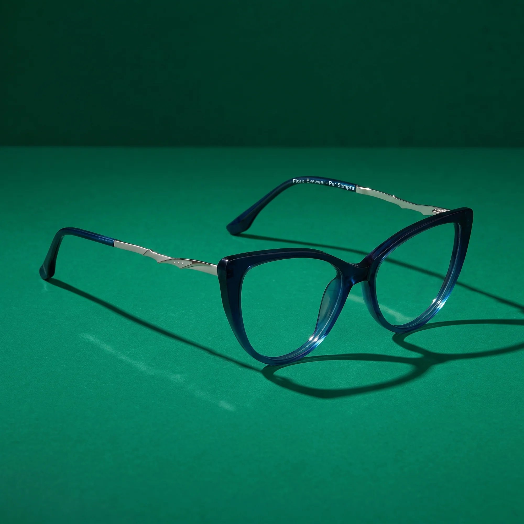 Fiore 1010 eyeglasses in blue – still life on a seamless emerald studio backdrop