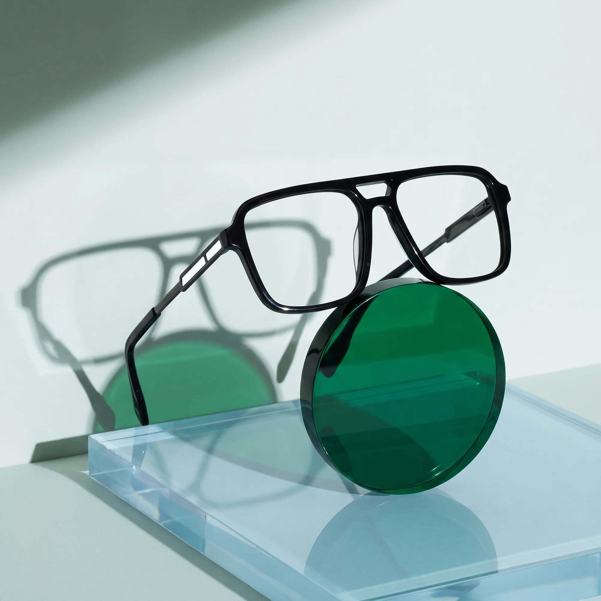Fiore 1014 eyeglasses in black – on a cobalt acrylic disc in soft daylight
