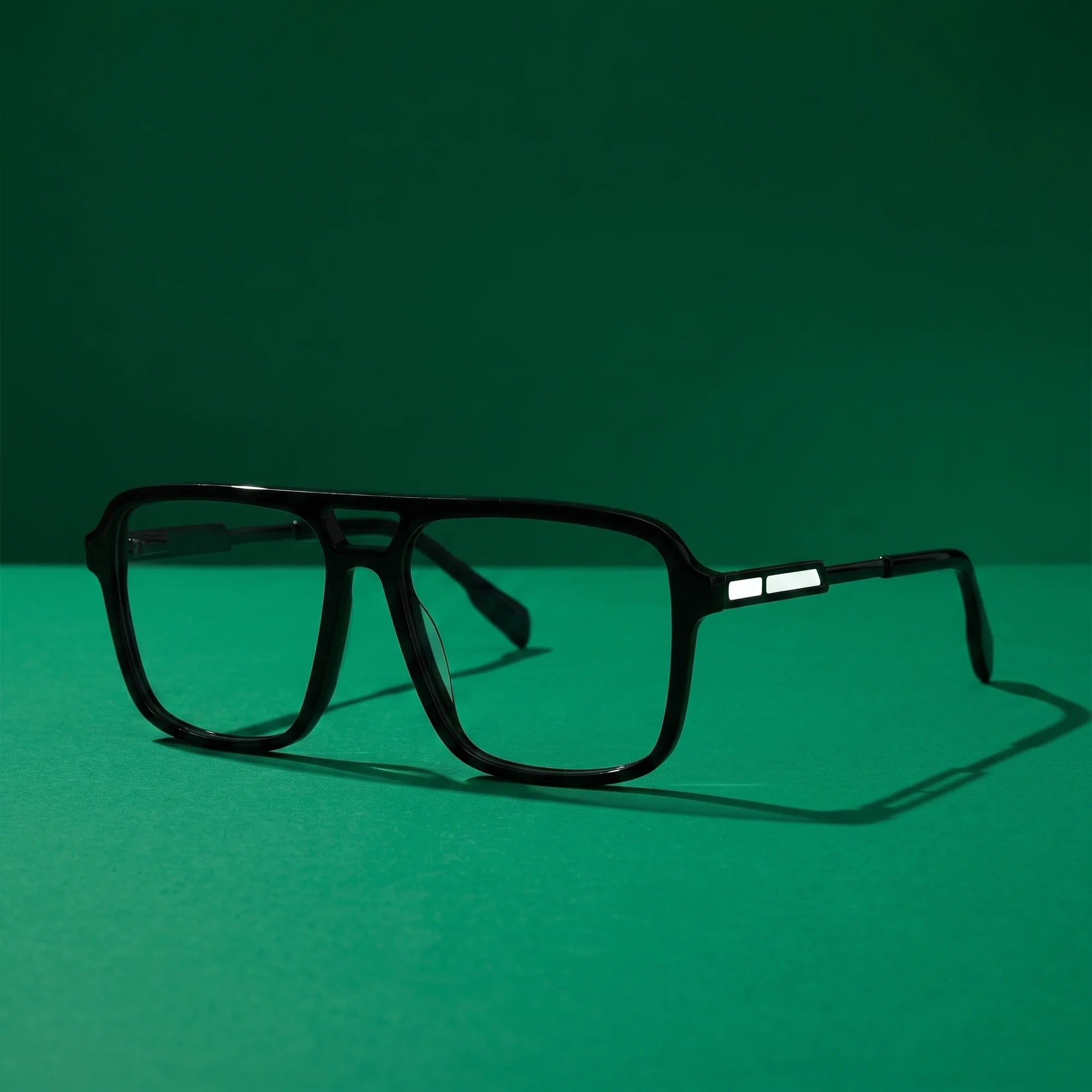 Fiore 1014 eyeglasses in black – still life on a seamless emerald studio backdrop