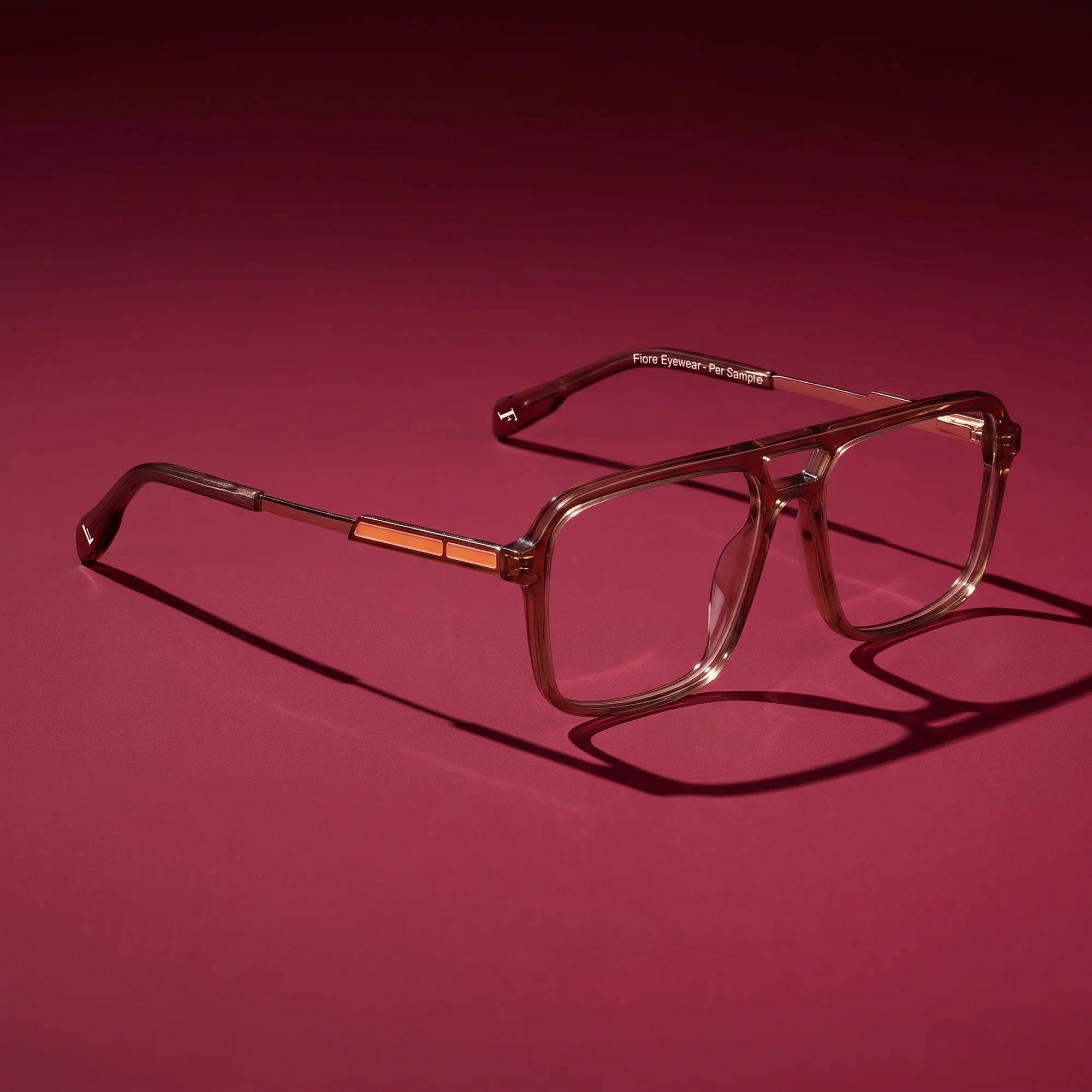 Fiore 1014 eyeglasses in brown – editorial still life on a saturated burgundy set