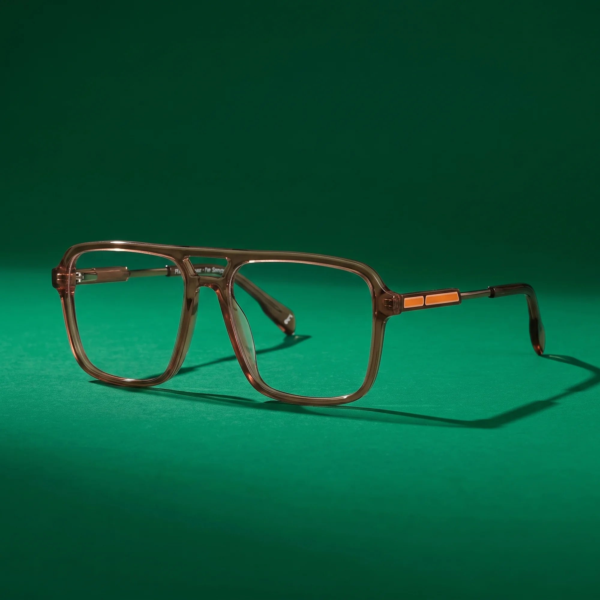 Fiore 1014 eyeglasses in brown – still life on a seamless emerald studio backdrop