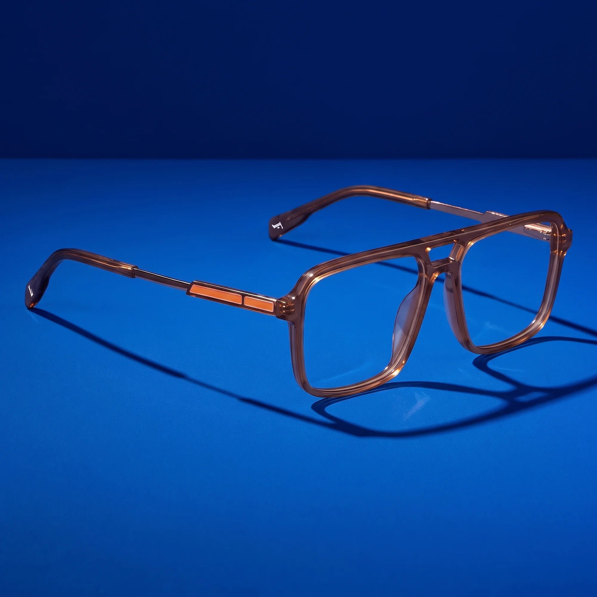 Fiore 1014 eyeglasses in brown – hero still life against a deep cobalt backdrop