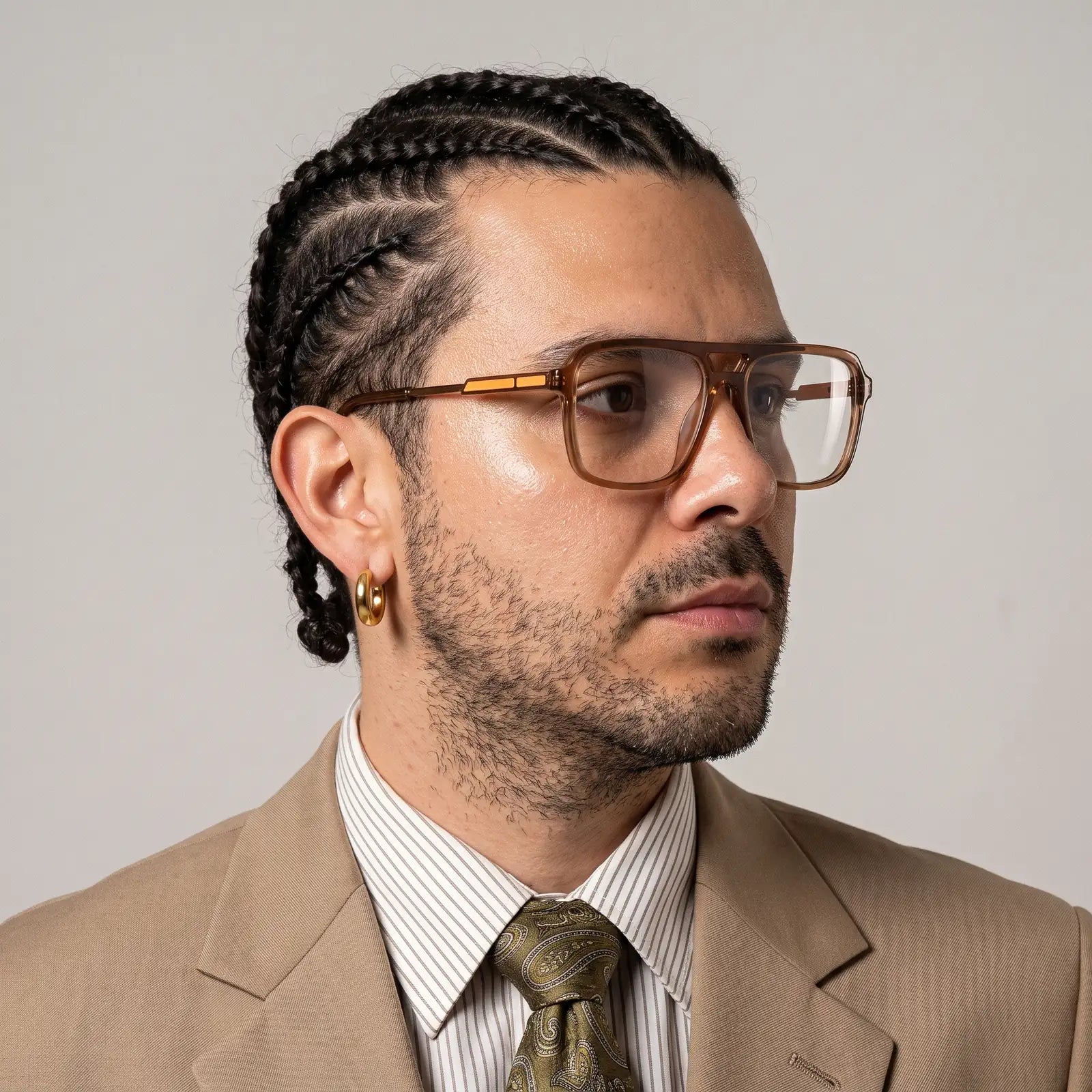 Fiore 1014 eyeglasses in brown, worn by a model – campaign portrait, clean beige studio three-quarter portrait
