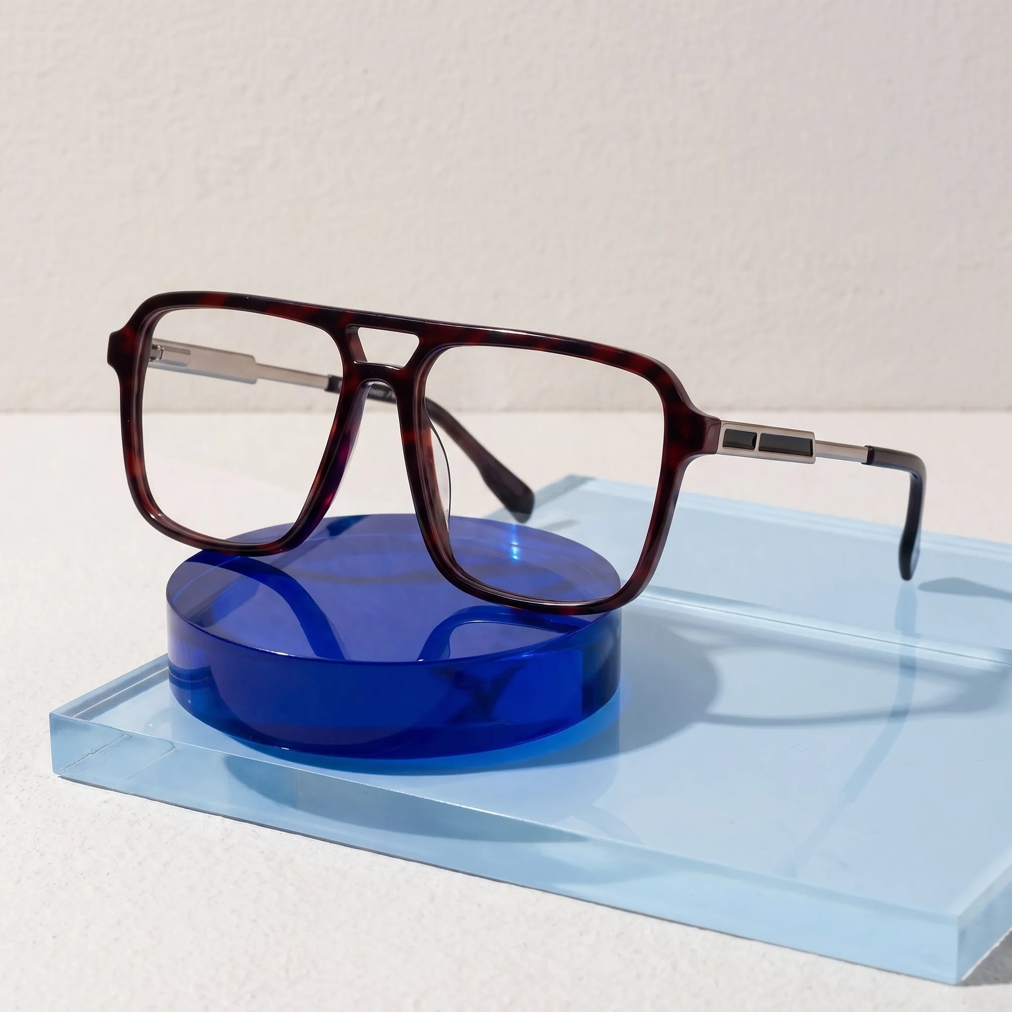 Fiore 1014 eyeglasses in tortoiseshell – on a cobalt acrylic disc in soft daylight