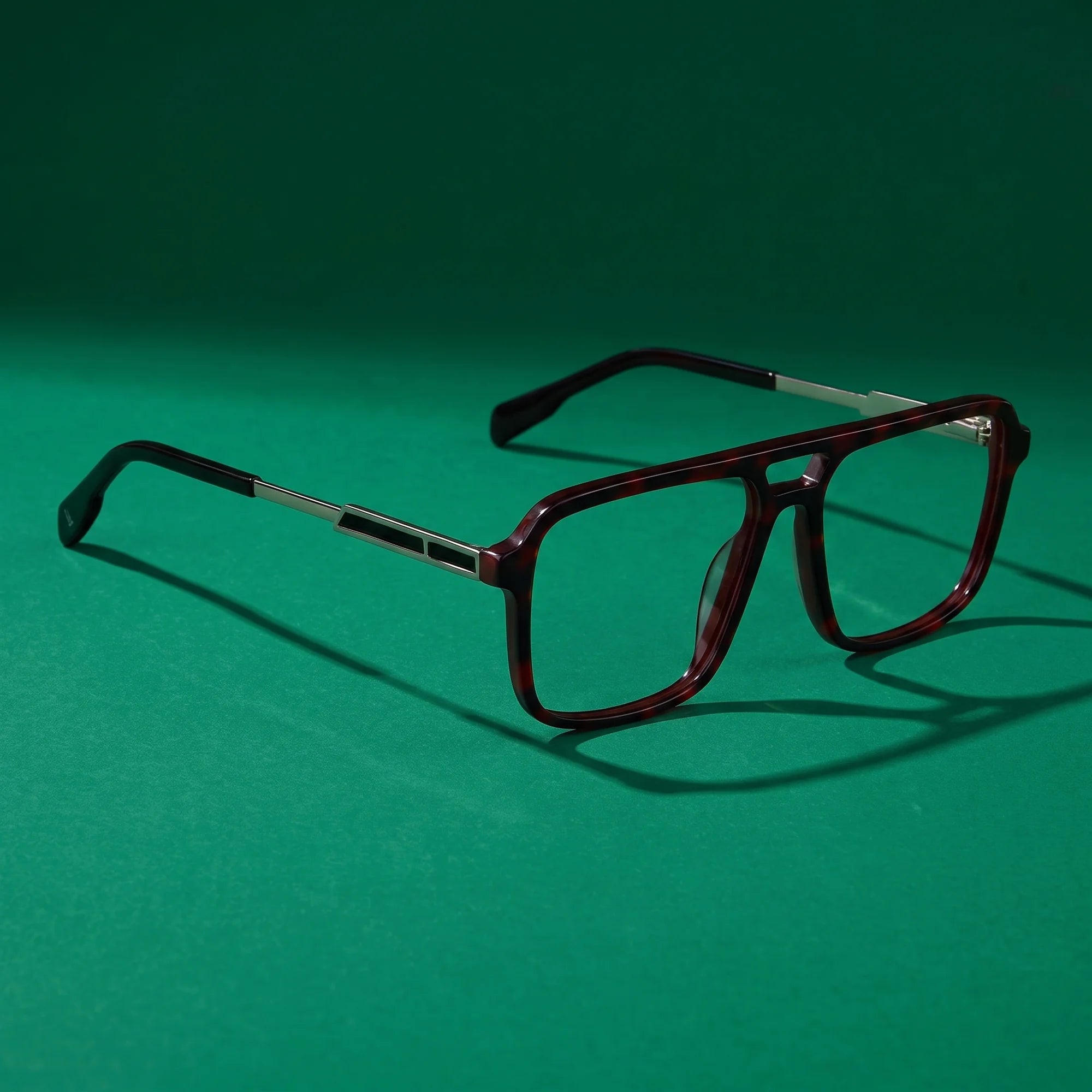 Fiore 1014 eyeglasses in tortoiseshell – editorial still life on a saturated emerald set