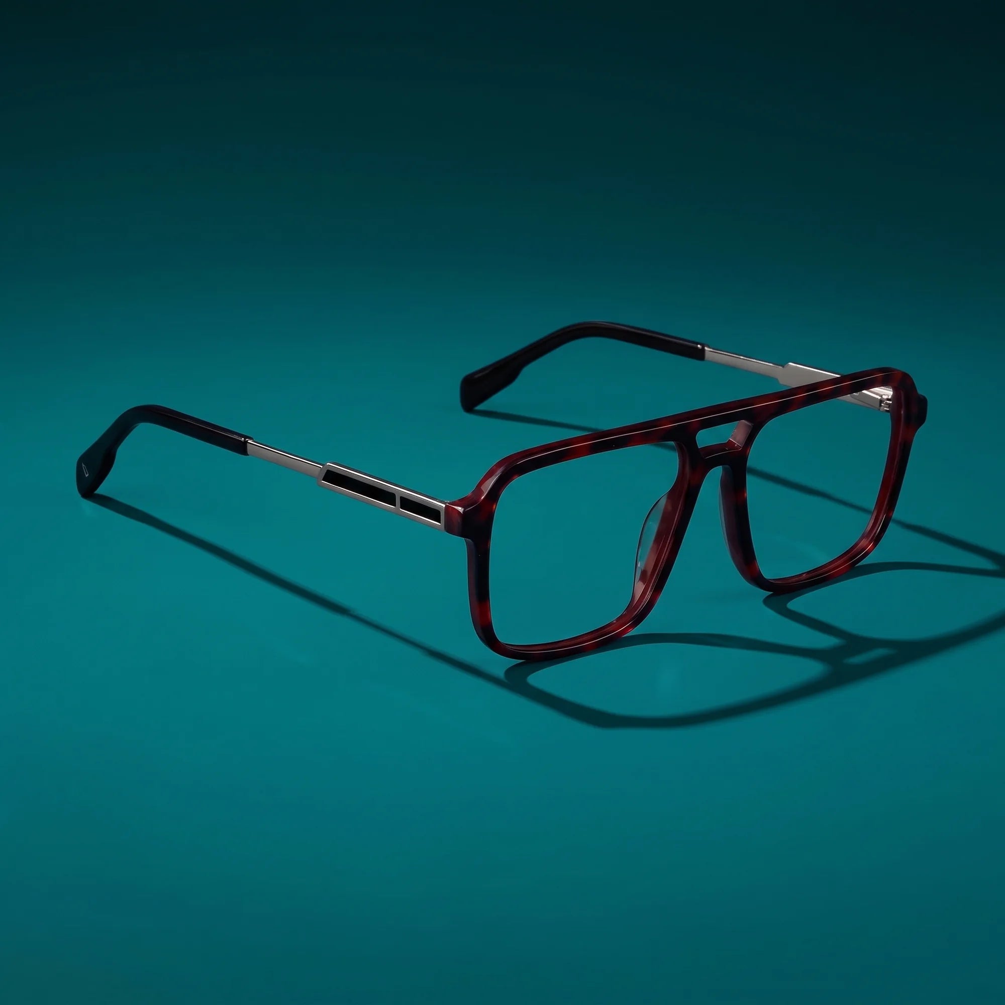 Fiore 1014 eyeglasses in tortoiseshell – hero still life against a deep teal backdrop