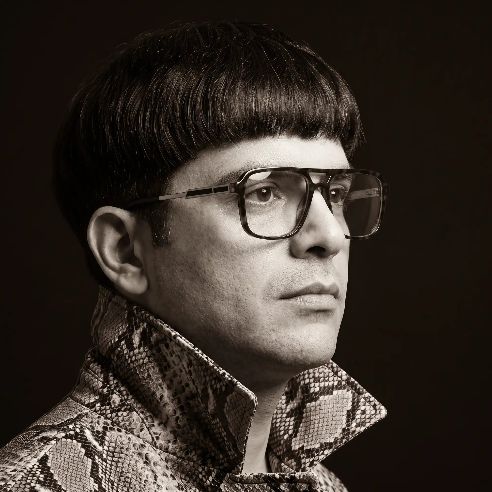 Fiore 1014 eyeglasses in tortoiseshell, worn by a model – campaign portrait, monochrome studio portrait, red graphic accents