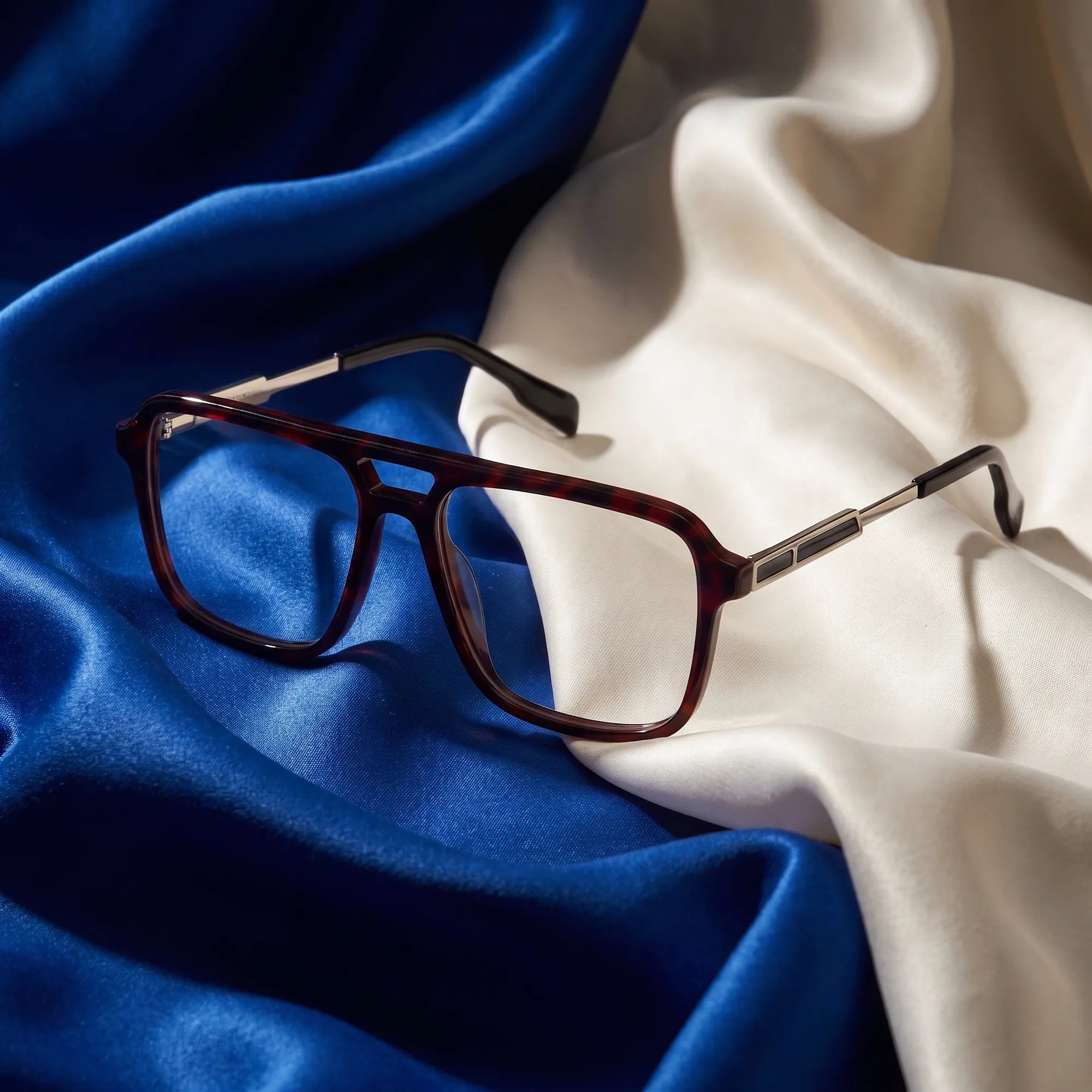 Fiore 1014 eyeglasses in tortoiseshell – resting on draped cobalt and ivory silk