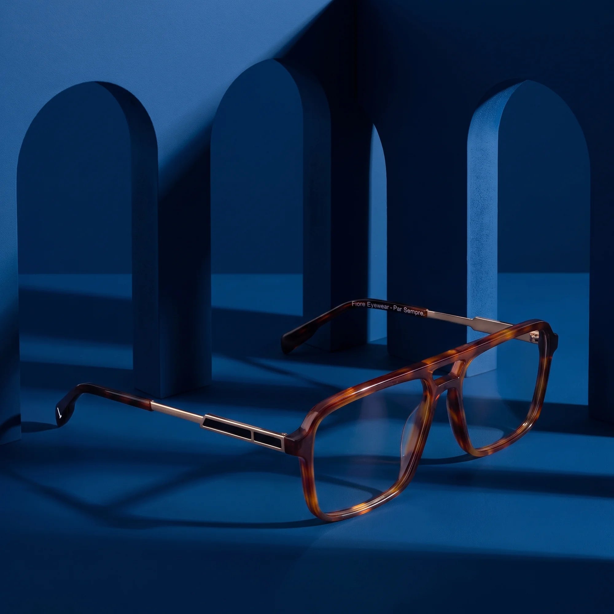 Fiore 1014 eyeglasses in brown tortoiseshell – displayed on a midnight blue podium among arches