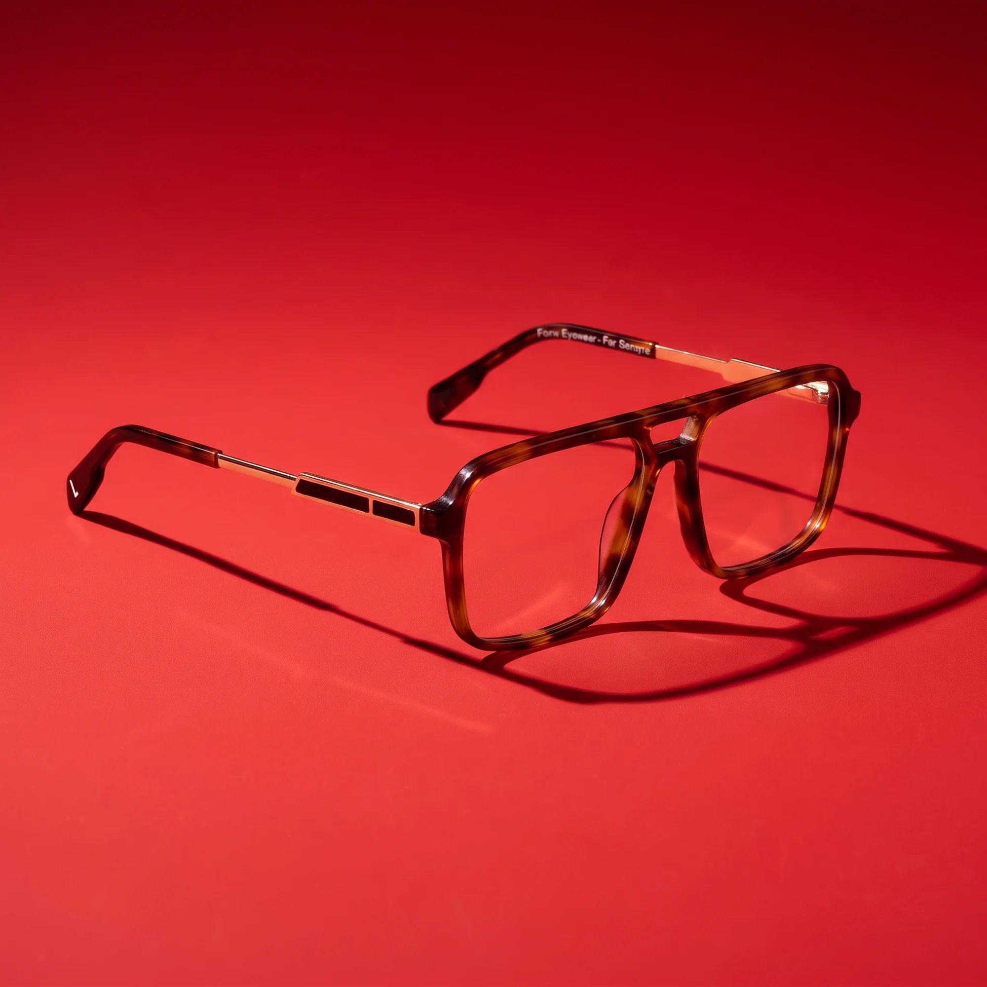 Fiore 1014 eyeglasses in brown tortoiseshell – hero still life against a deep vivid red backdrop