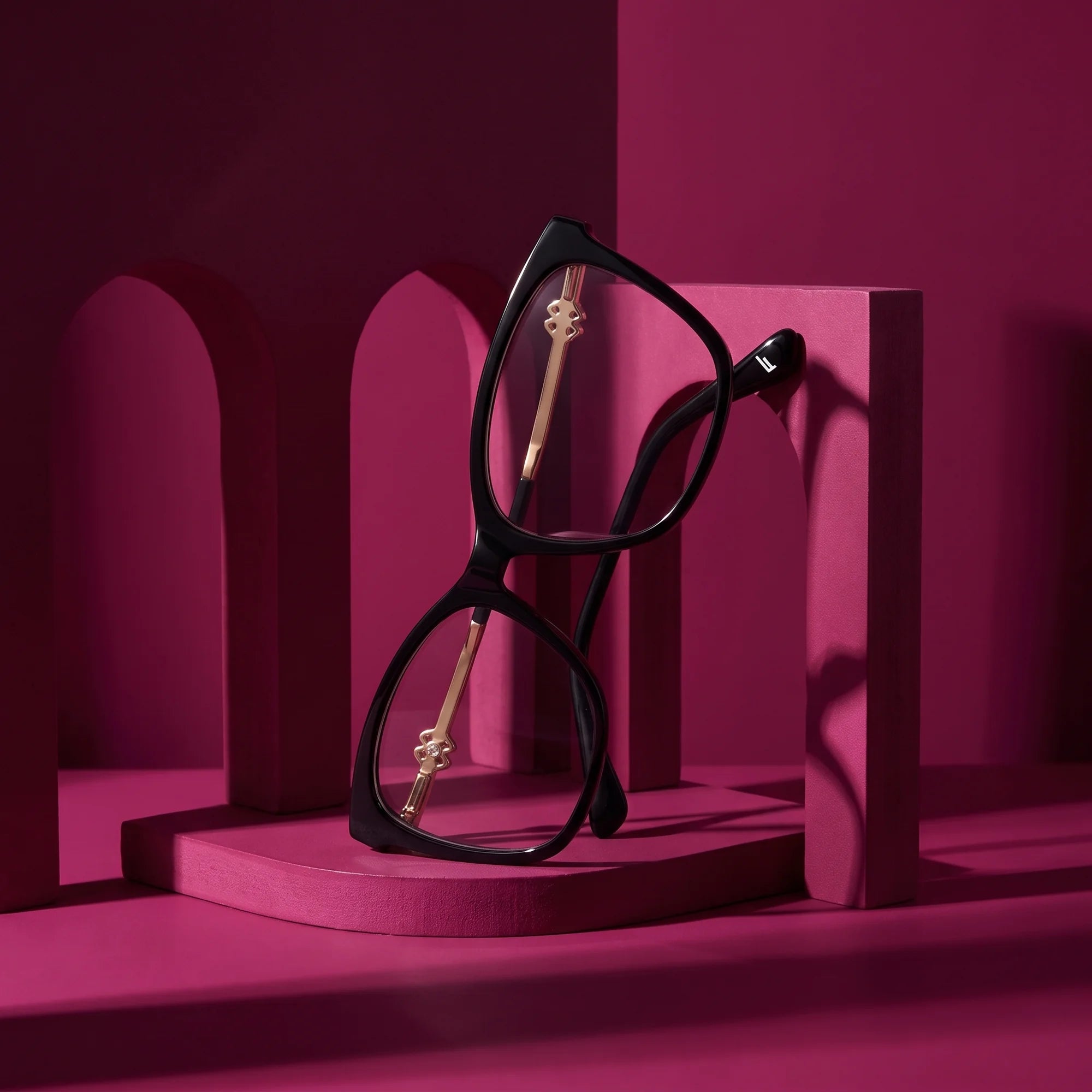 Fiore 10172 eyeglasses in black – staged on a sculptural magenta architecture set