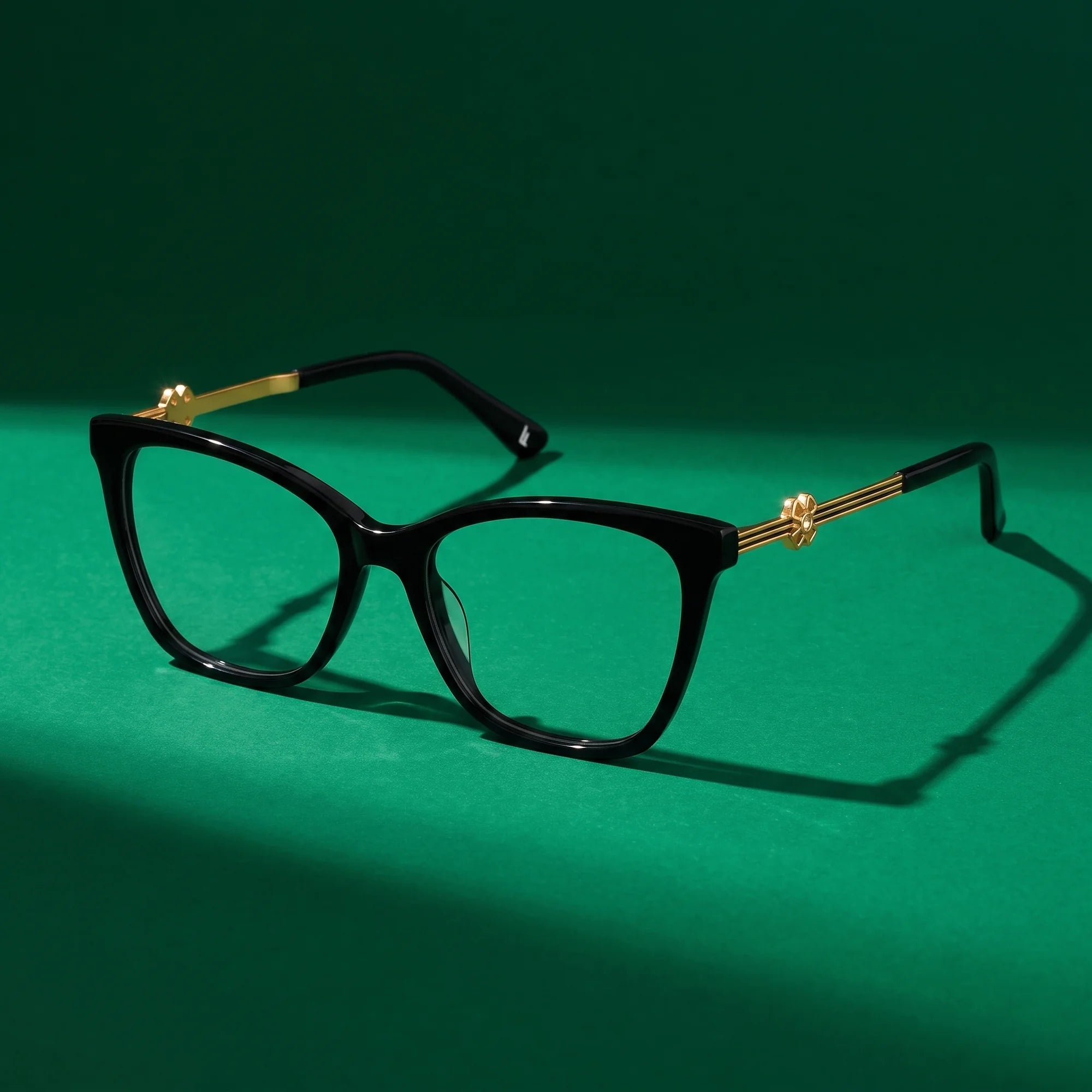 Fiore 10172 eyeglasses in black – still life on a seamless emerald studio backdrop