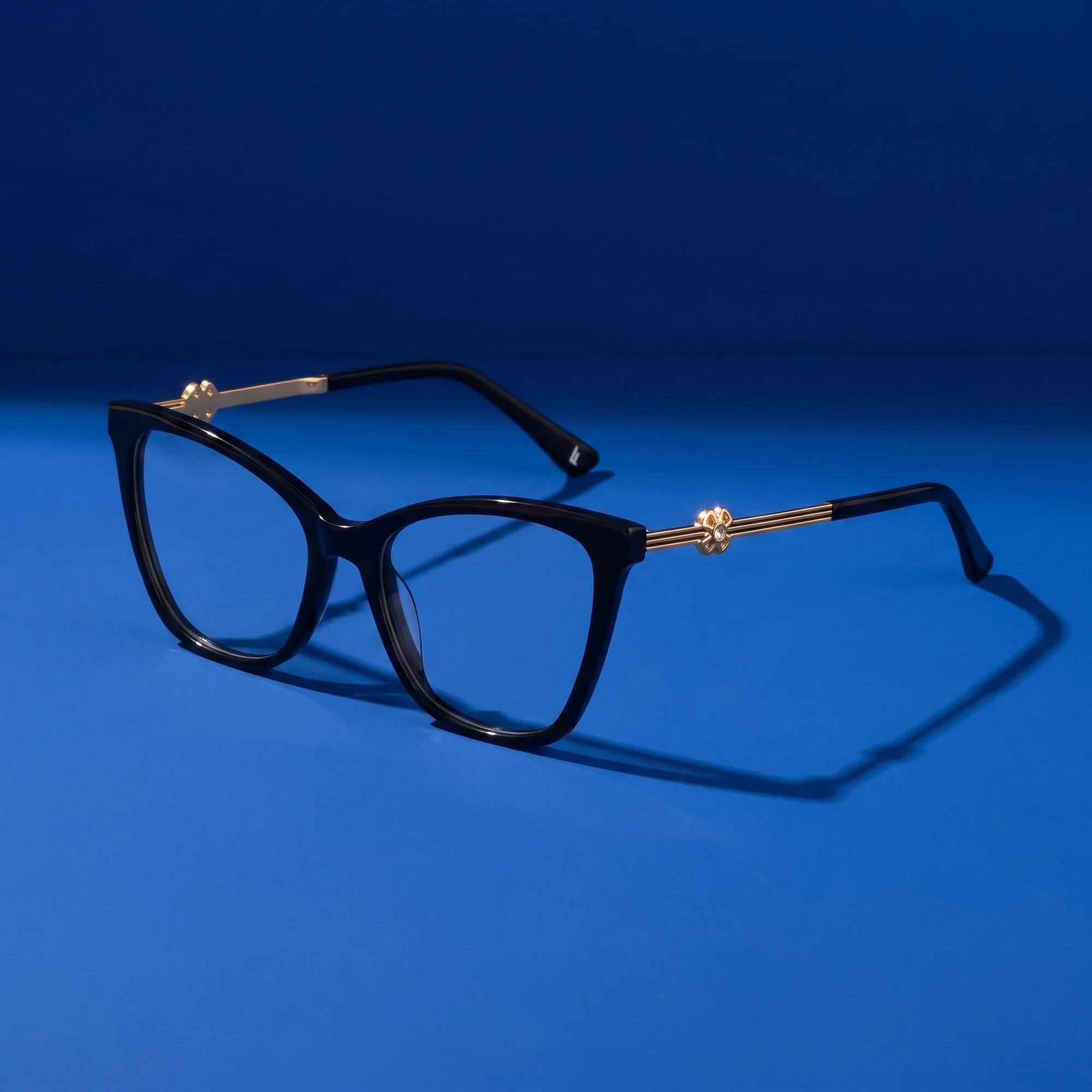 Fiore 10172 eyeglasses in black – hero still life against a deep cobalt backdrop