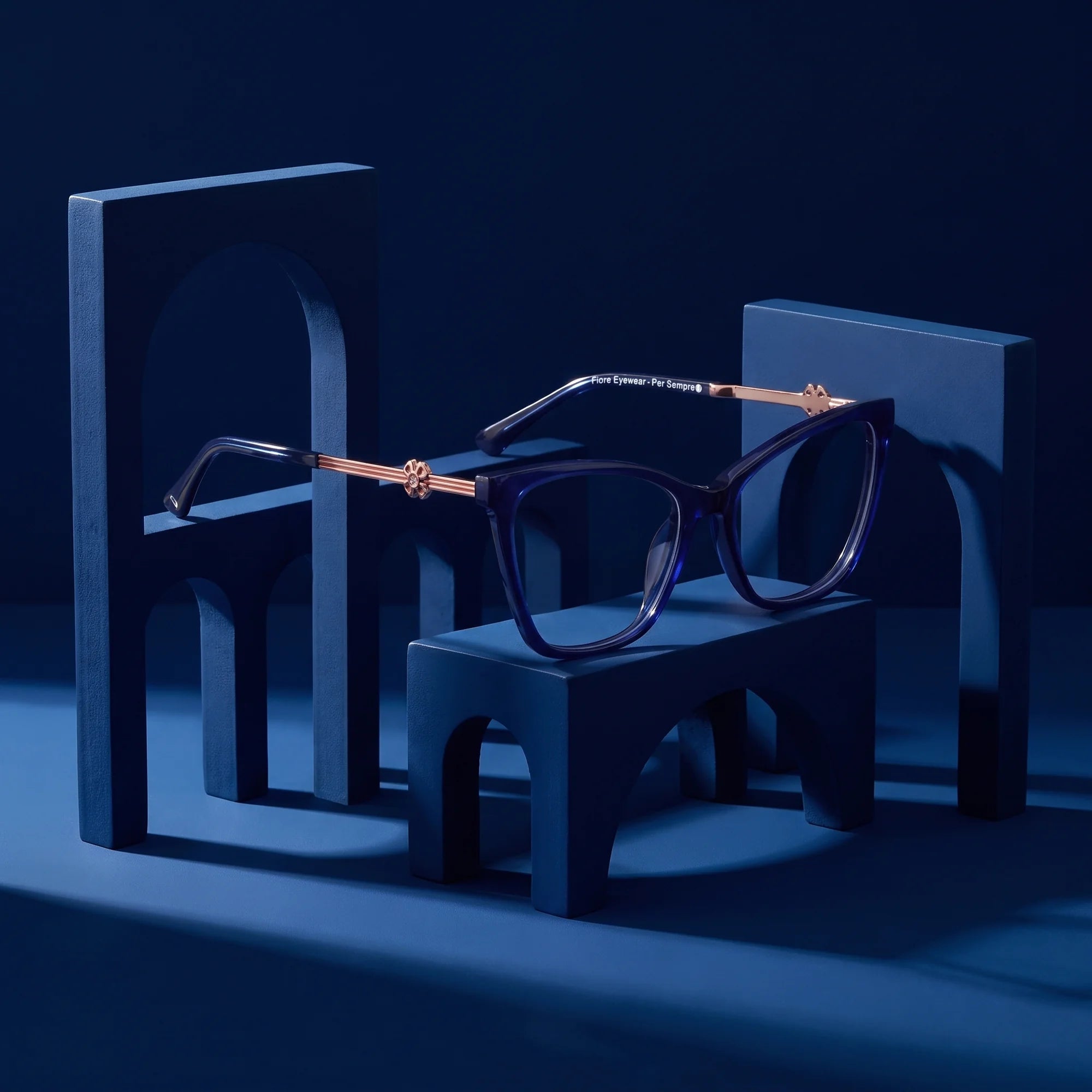 Fiore 10172 eyeglasses in blue – staged on a sculptural midnight blue architecture set