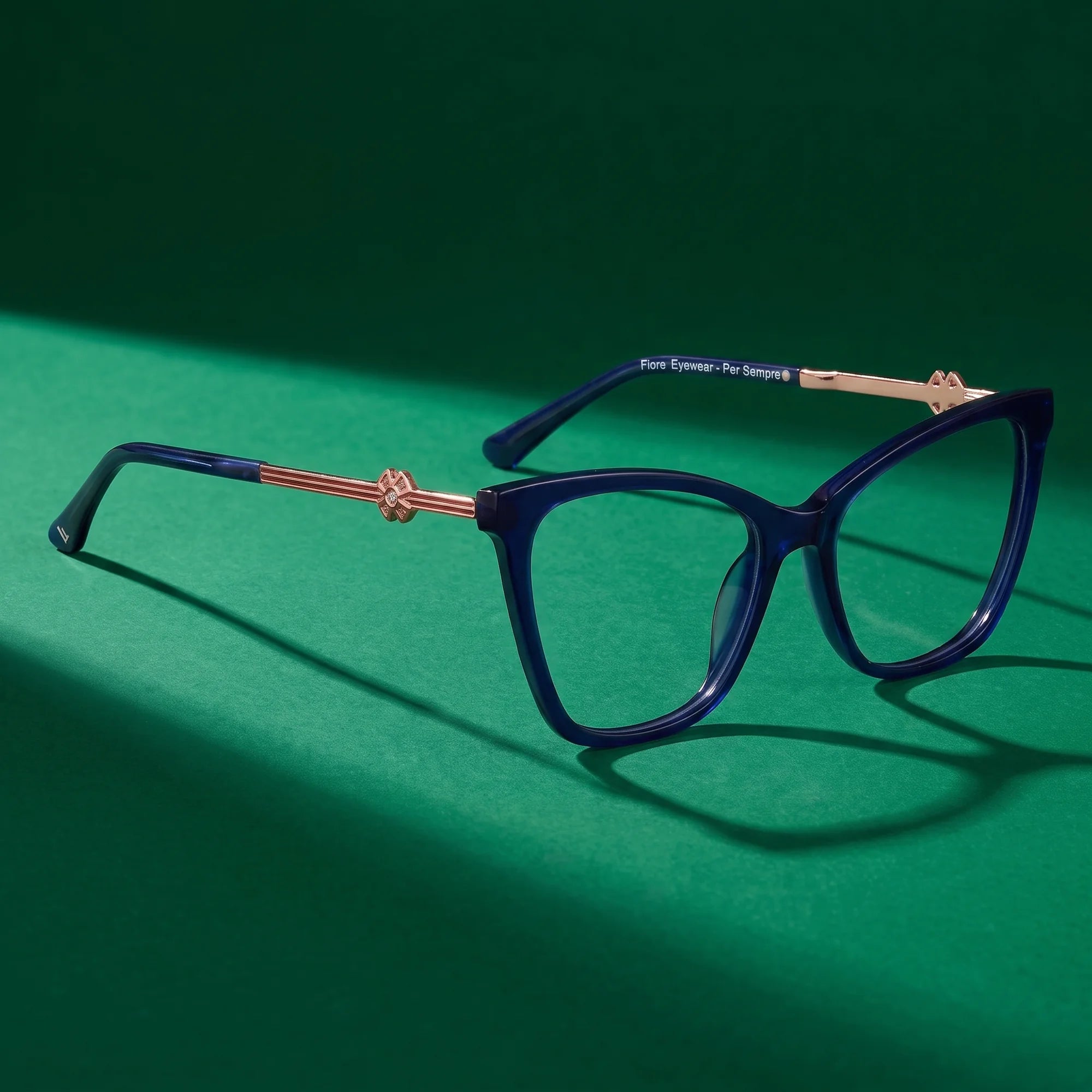 Fiore 10172 eyeglasses in blue – editorial still life on a saturated emerald set