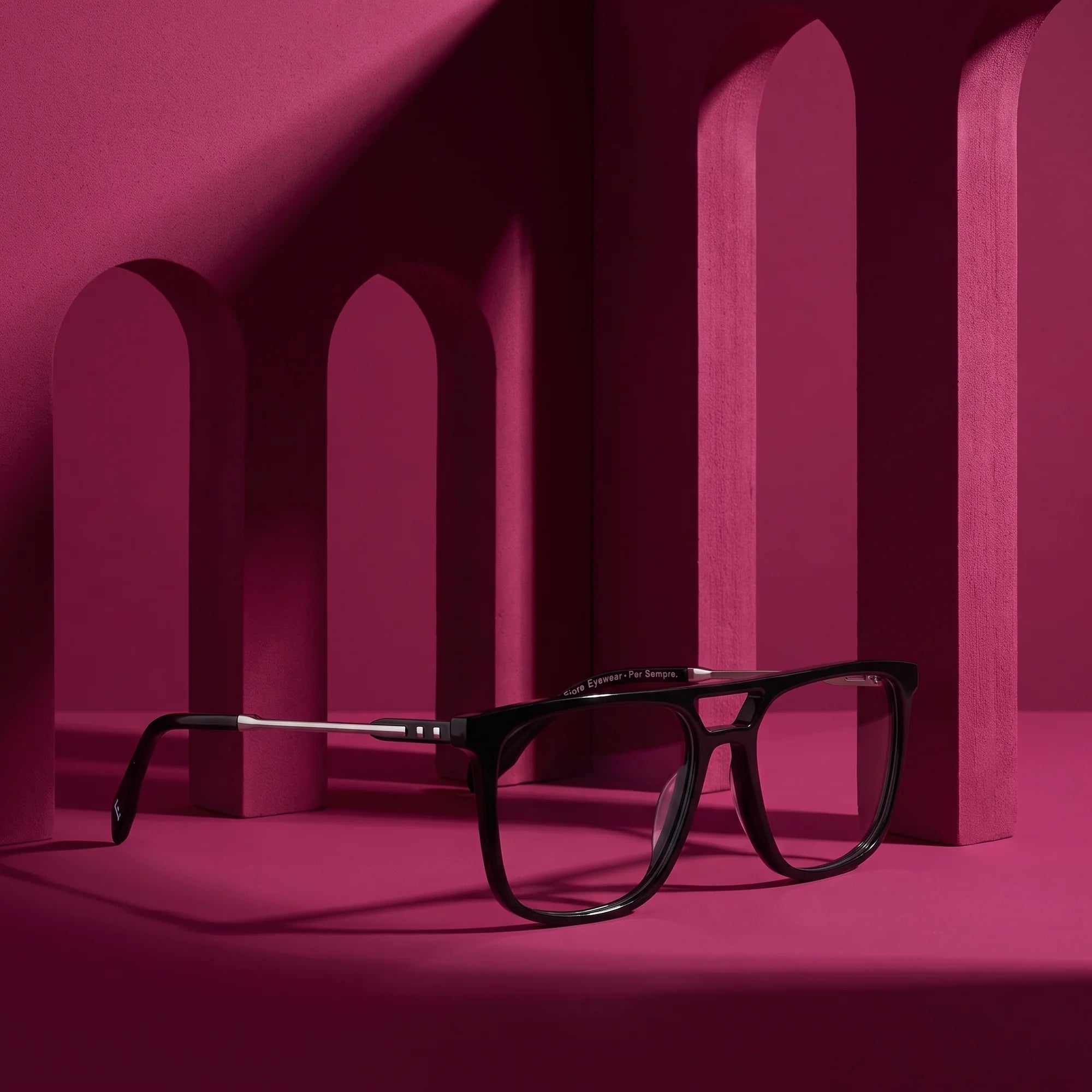 Fiore 10177 eyeglasses in black – staged on a sculptural magenta architecture set