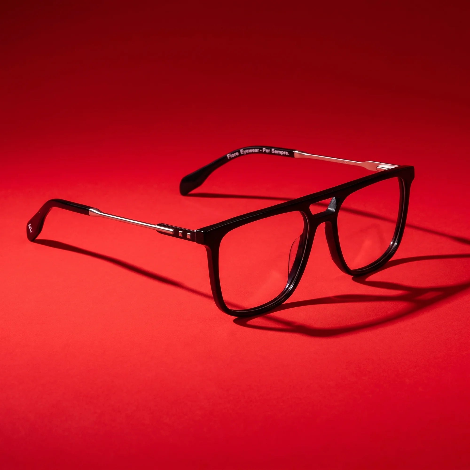 Fiore 10177 eyeglasses in black – editorial still life on a saturated vivid red set