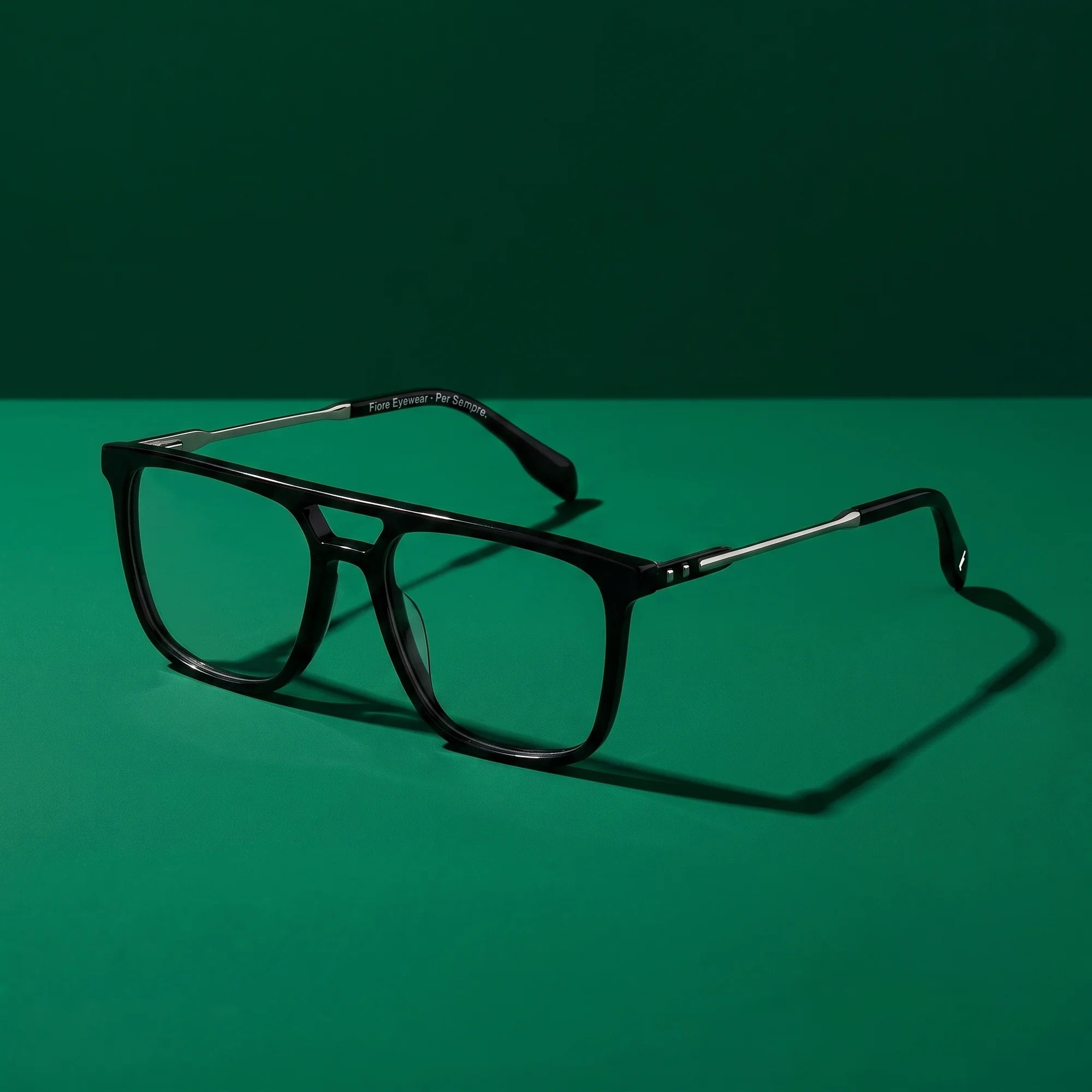 Fiore 10177 eyeglasses in black – still life on a seamless emerald studio backdrop