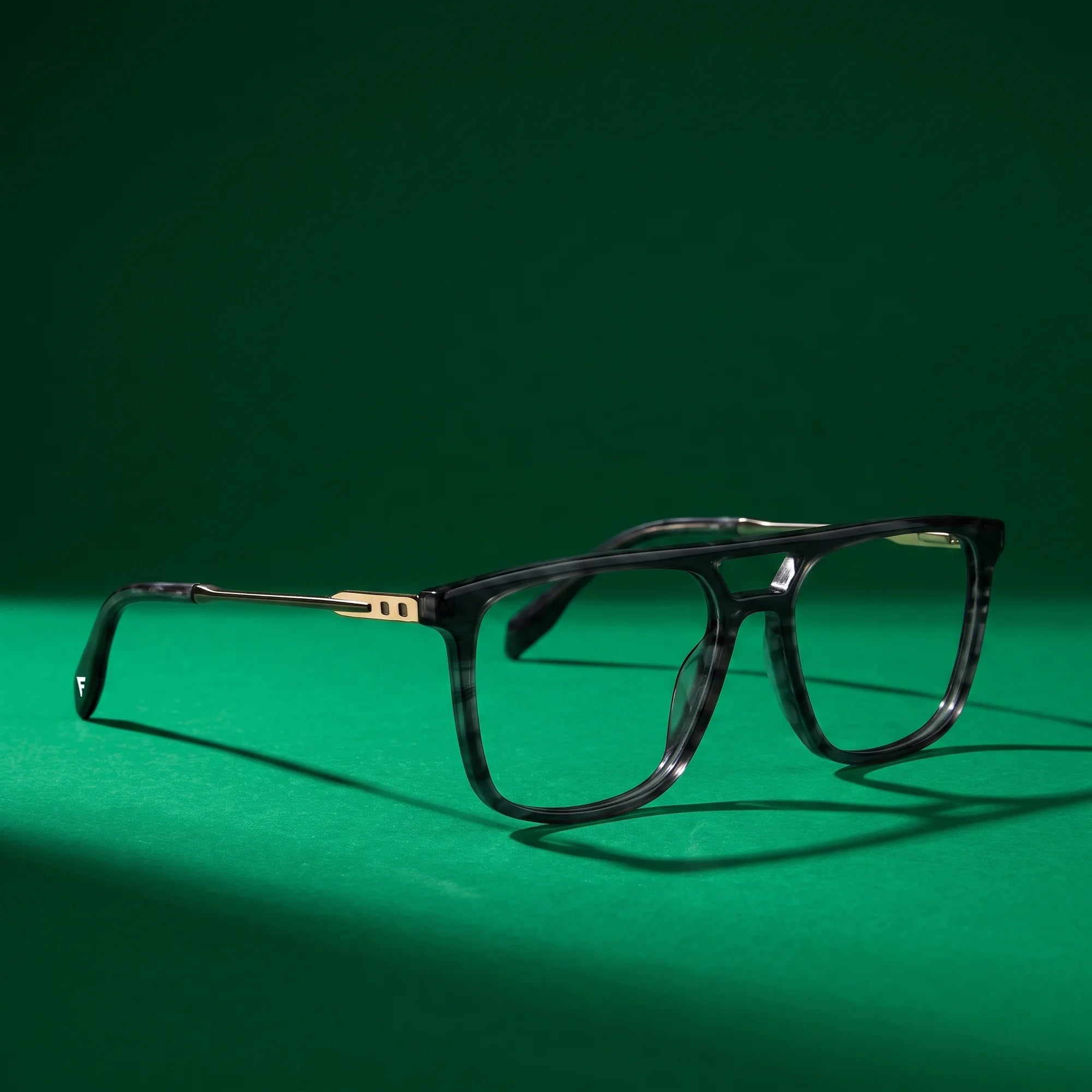 Fiore 10177 eyeglasses in grey – still life on a seamless emerald studio backdrop