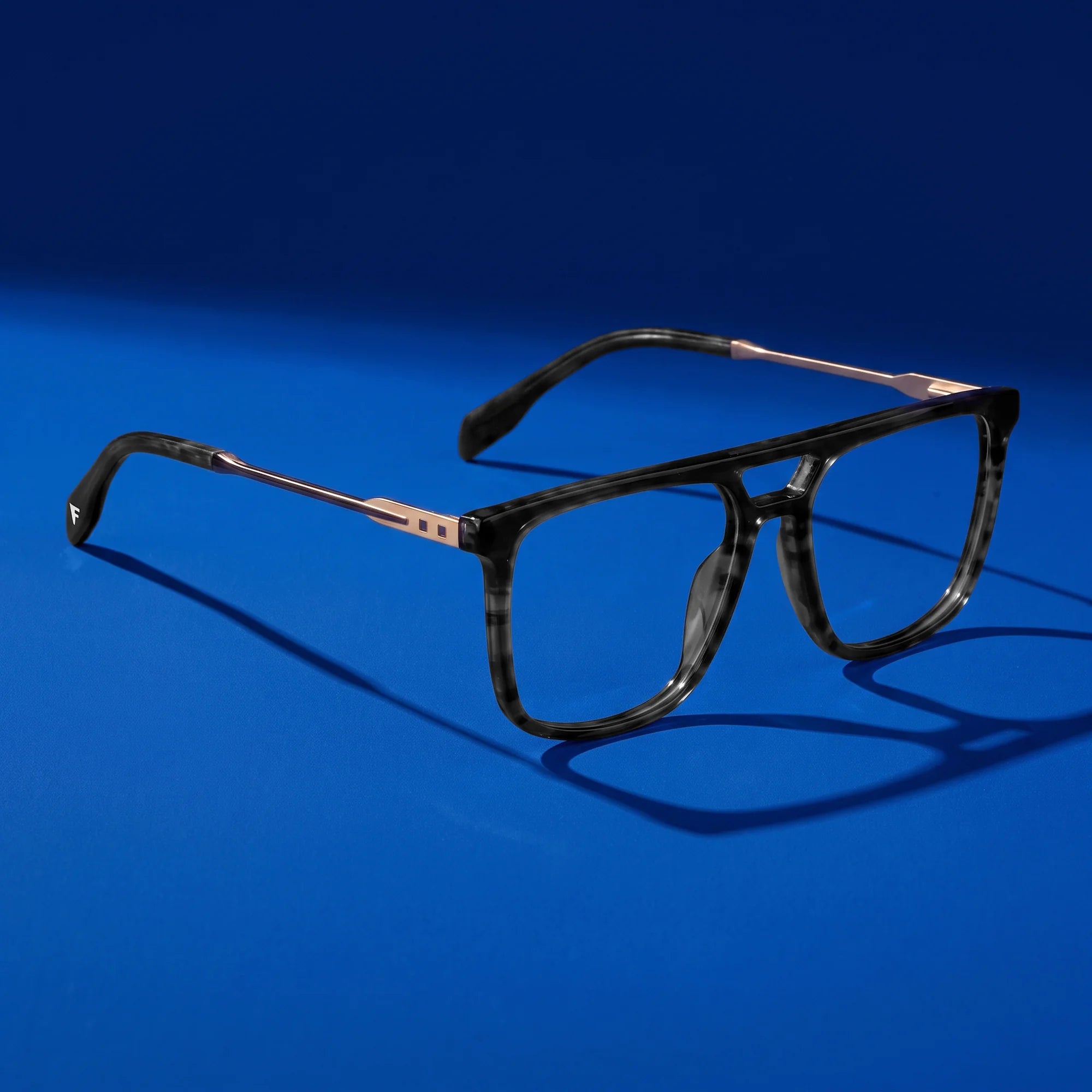 Fiore 10177 eyeglasses in grey – hero still life against a deep cobalt backdrop