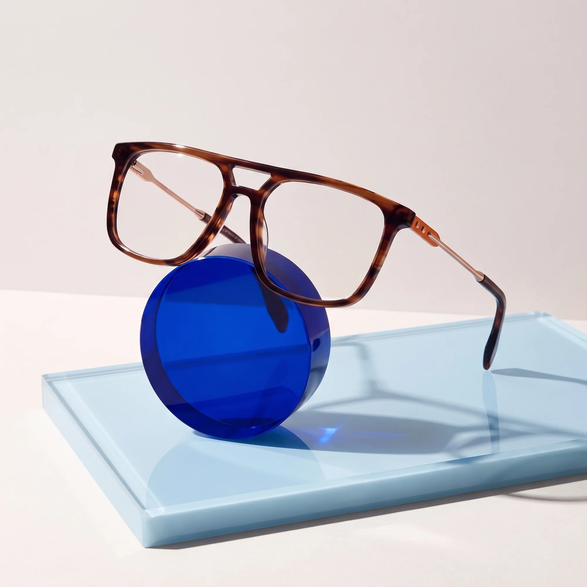Fiore 10177 eyeglasses in tortoiseshell – on a cobalt acrylic disc in soft daylight