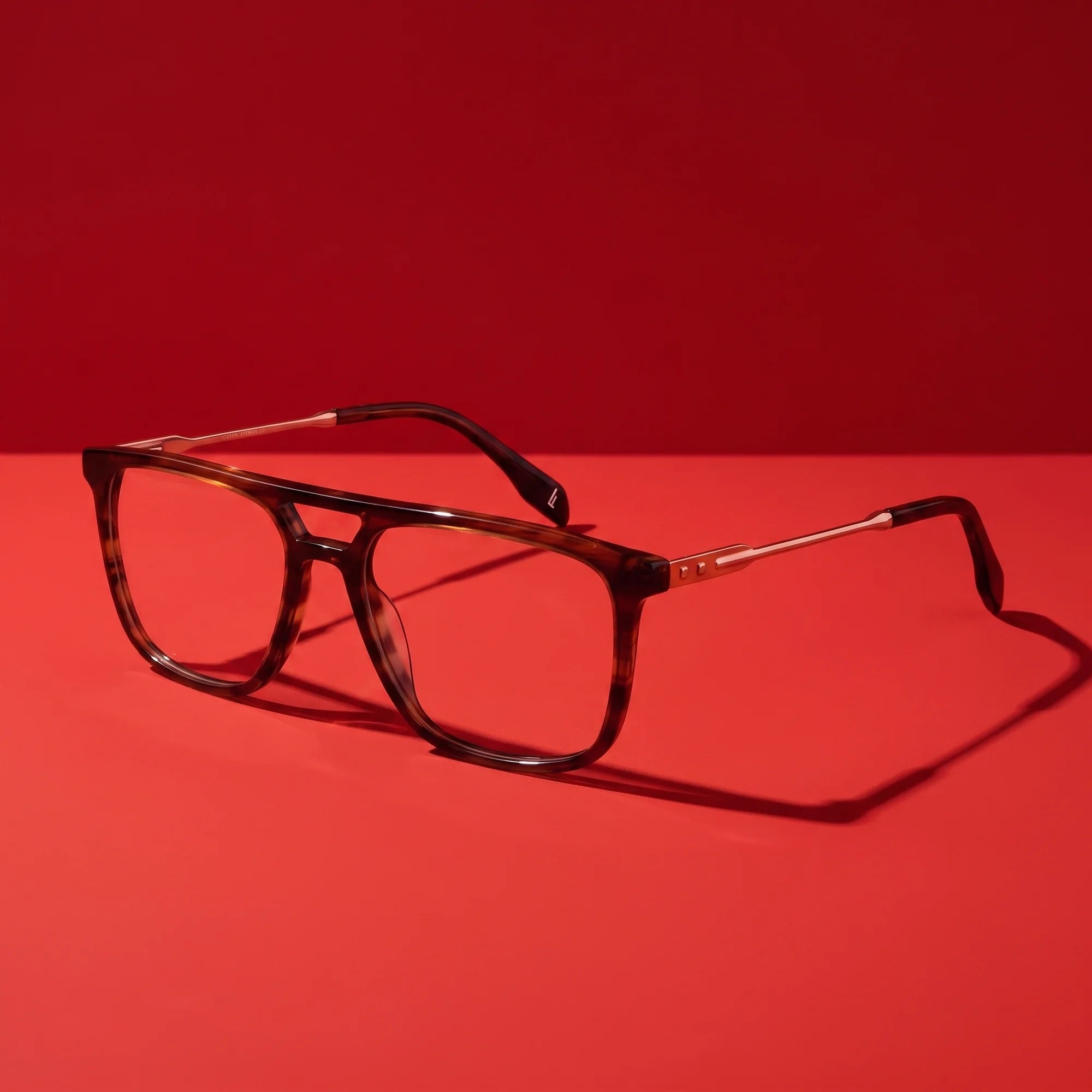 Fiore 10177 eyeglasses in tortoiseshell – hero still life against a deep vivid red backdrop