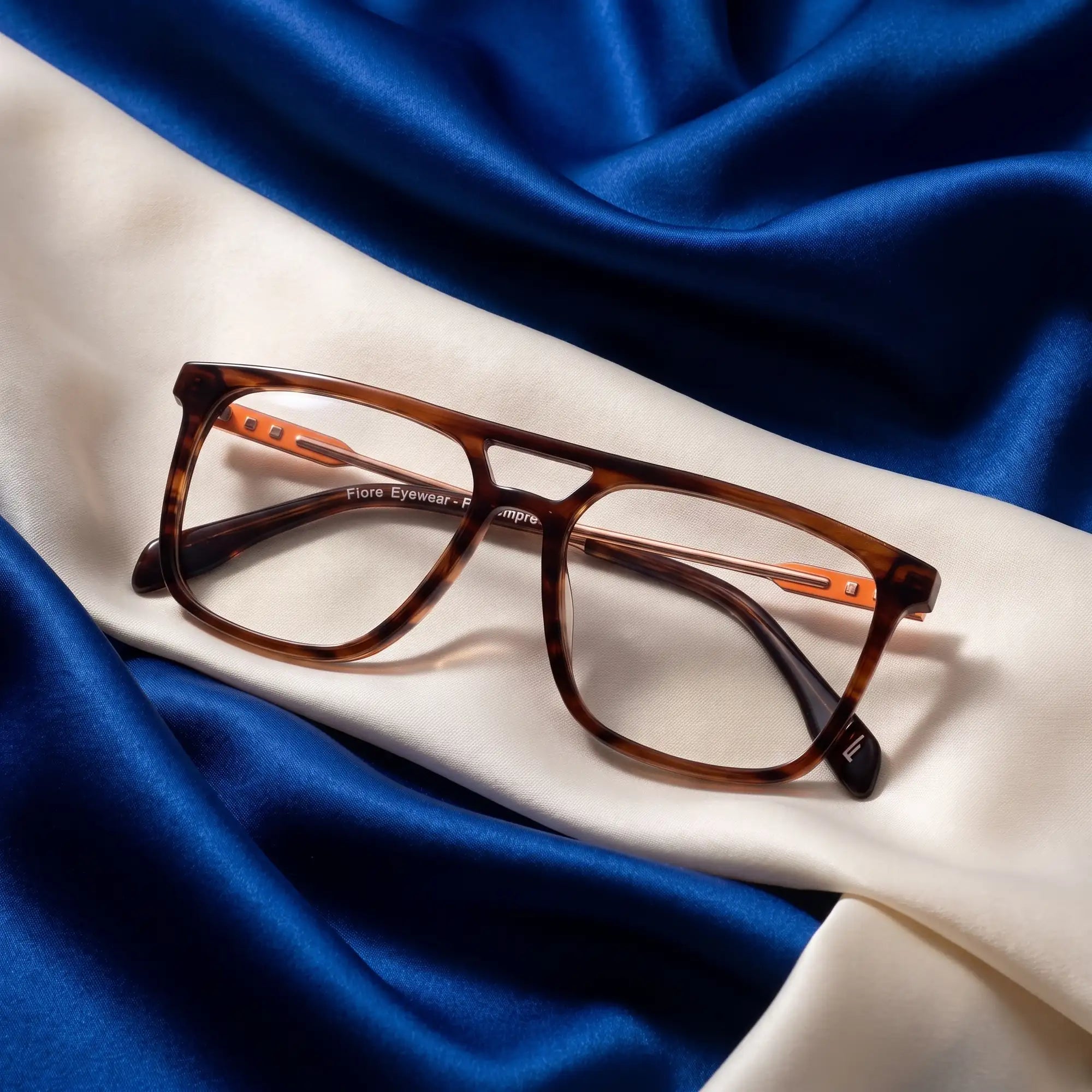 Fiore 10177 eyeglasses in tortoiseshell – resting on draped cobalt and ivory silk