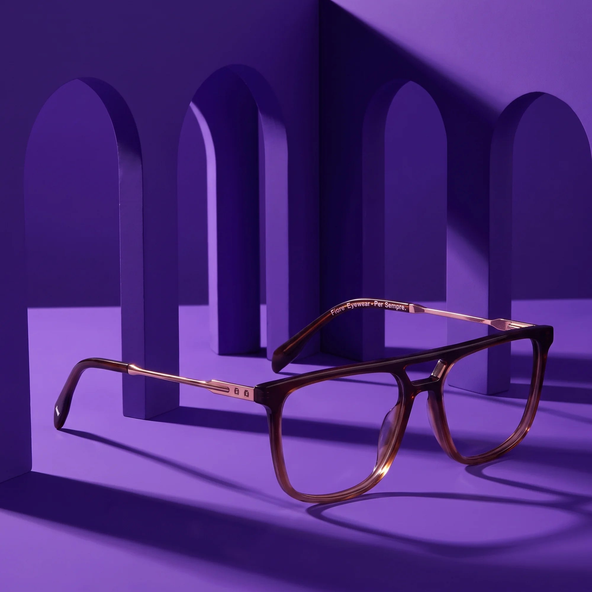 Fiore 10177 eyeglasses in brown – displayed on a violet podium among arches